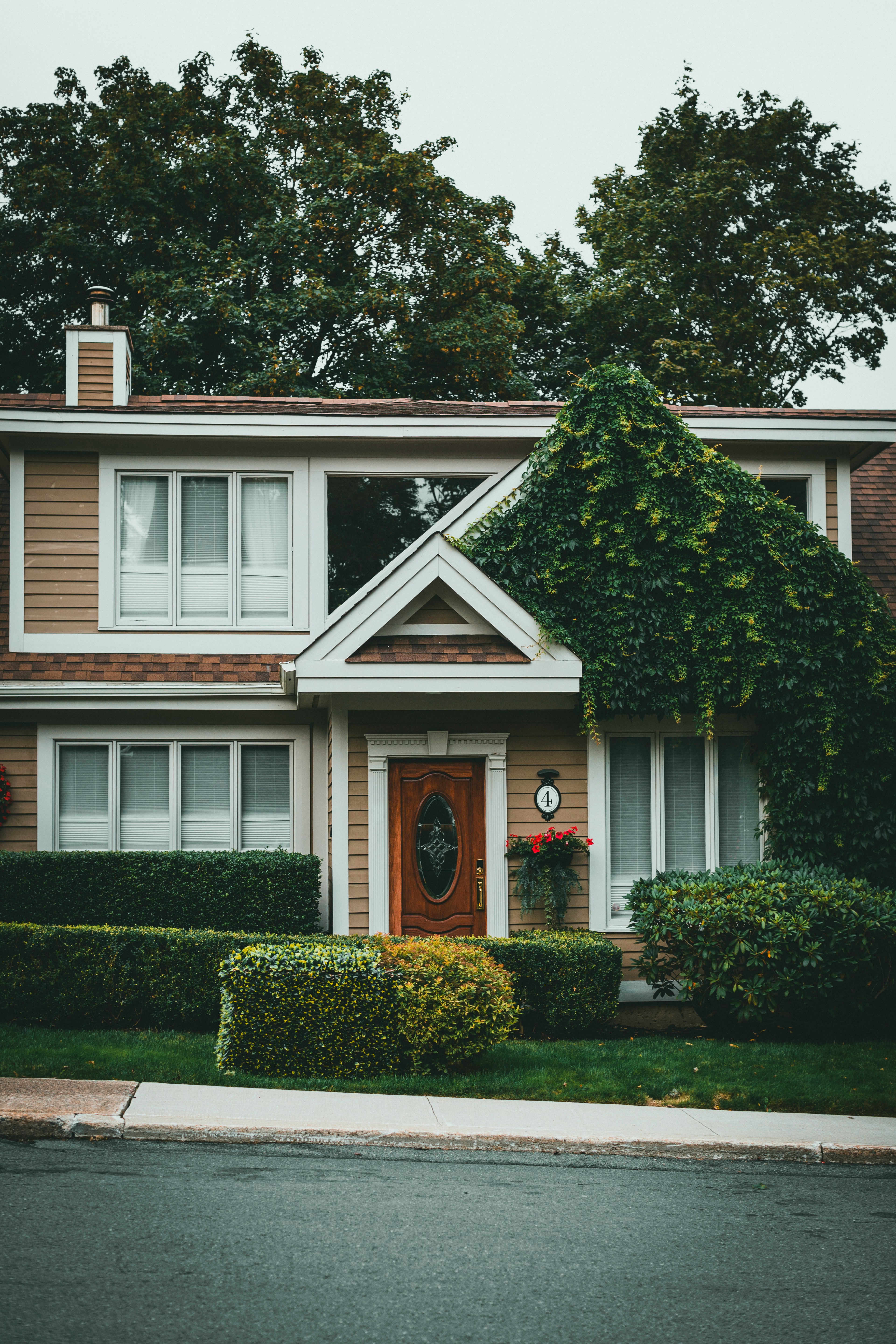 white and brown wooden house near green trees during daytime