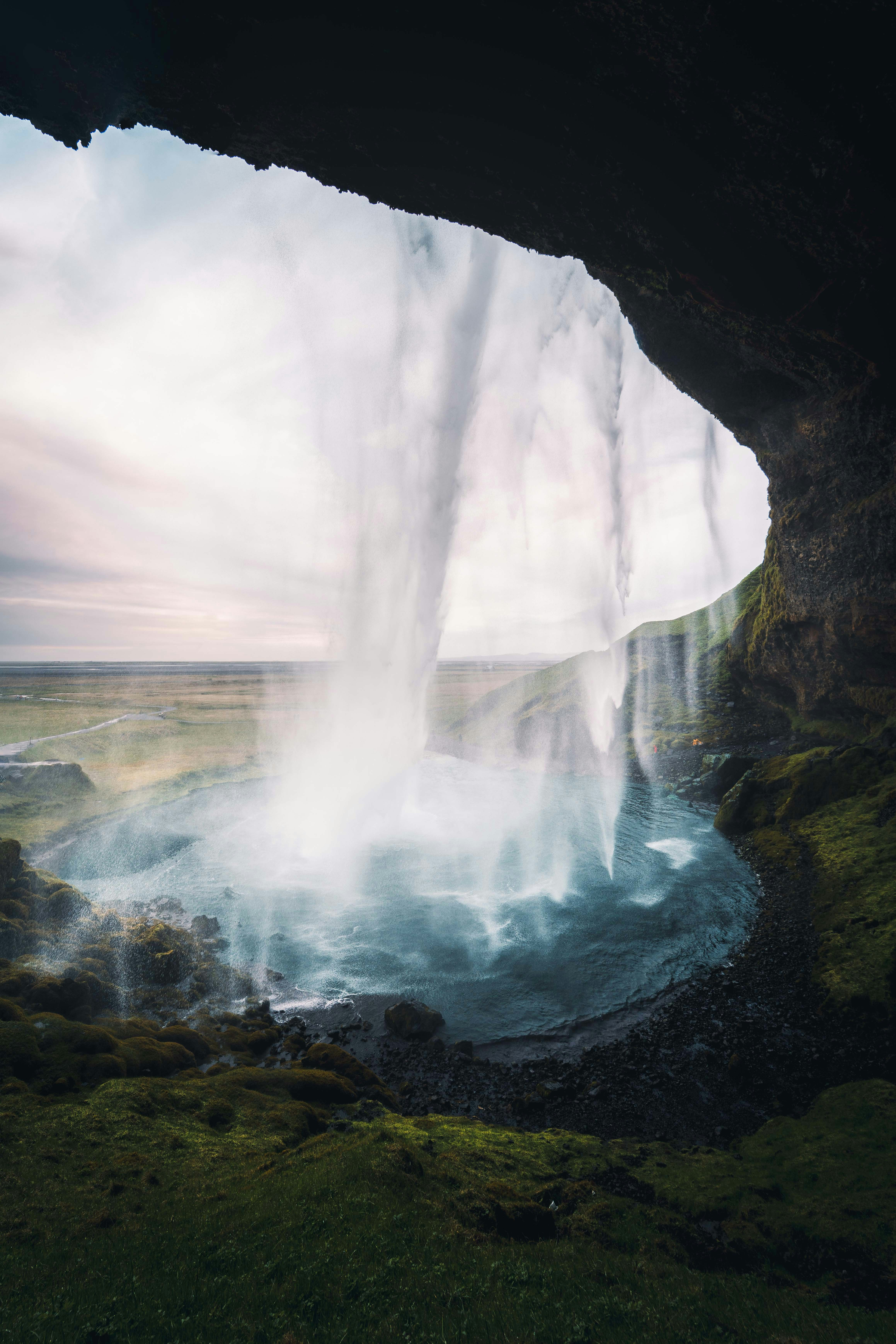 View of a waterfall from behind a cave.