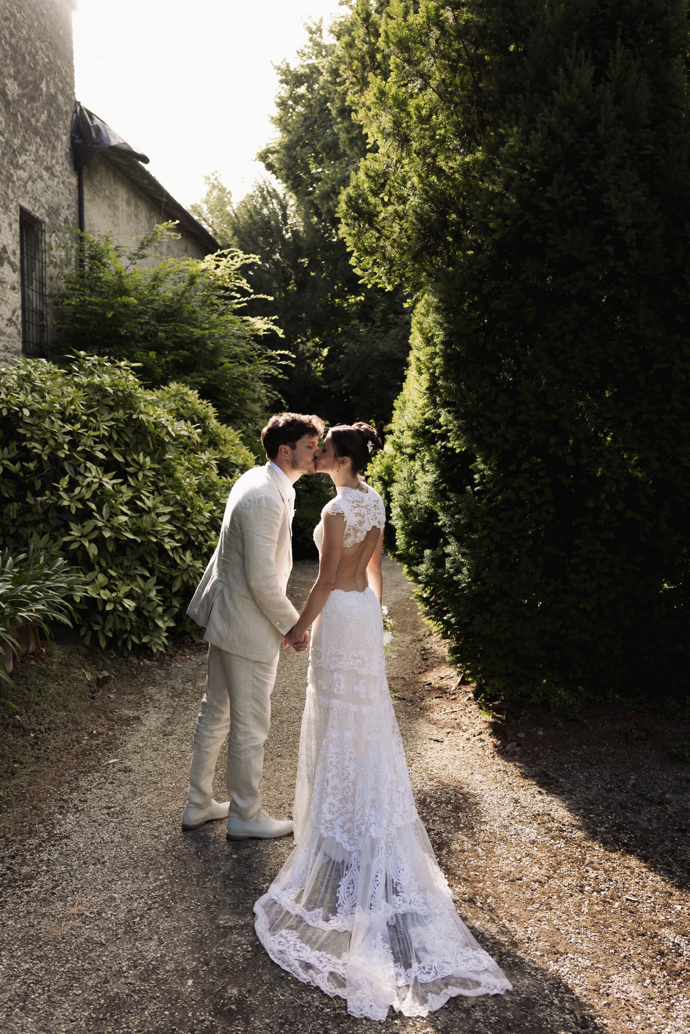 Sposi nel giardino della Rocca di Soragna, lei in abito bianco con velo, lui in completo chiaro, tra siepi di pietra