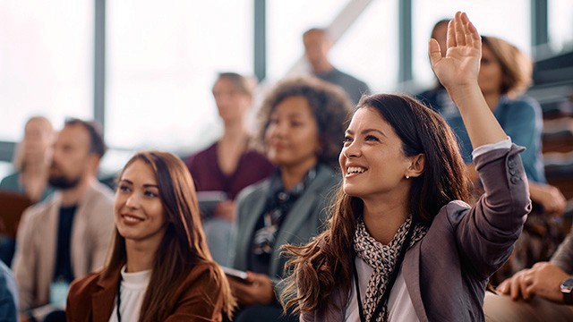 a woman in the audience raising her hand.