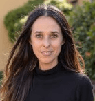 man sitting facing silver MacBook inside room