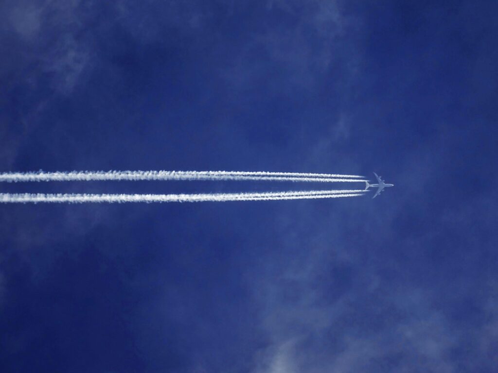 Blue sky with Plane leaving steam trails behind