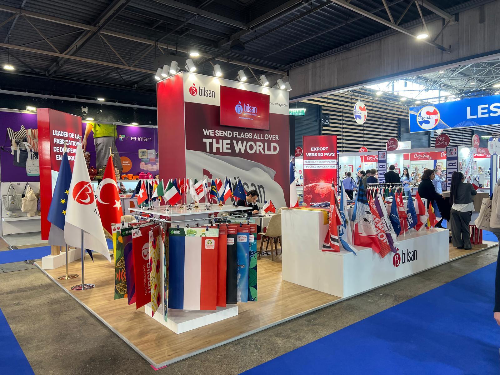 Bilsan exhibition stand at CTCO Lyon 2026, featuring an open island layout with flag displays, national flags, and a clear red-and-white corporate identity.