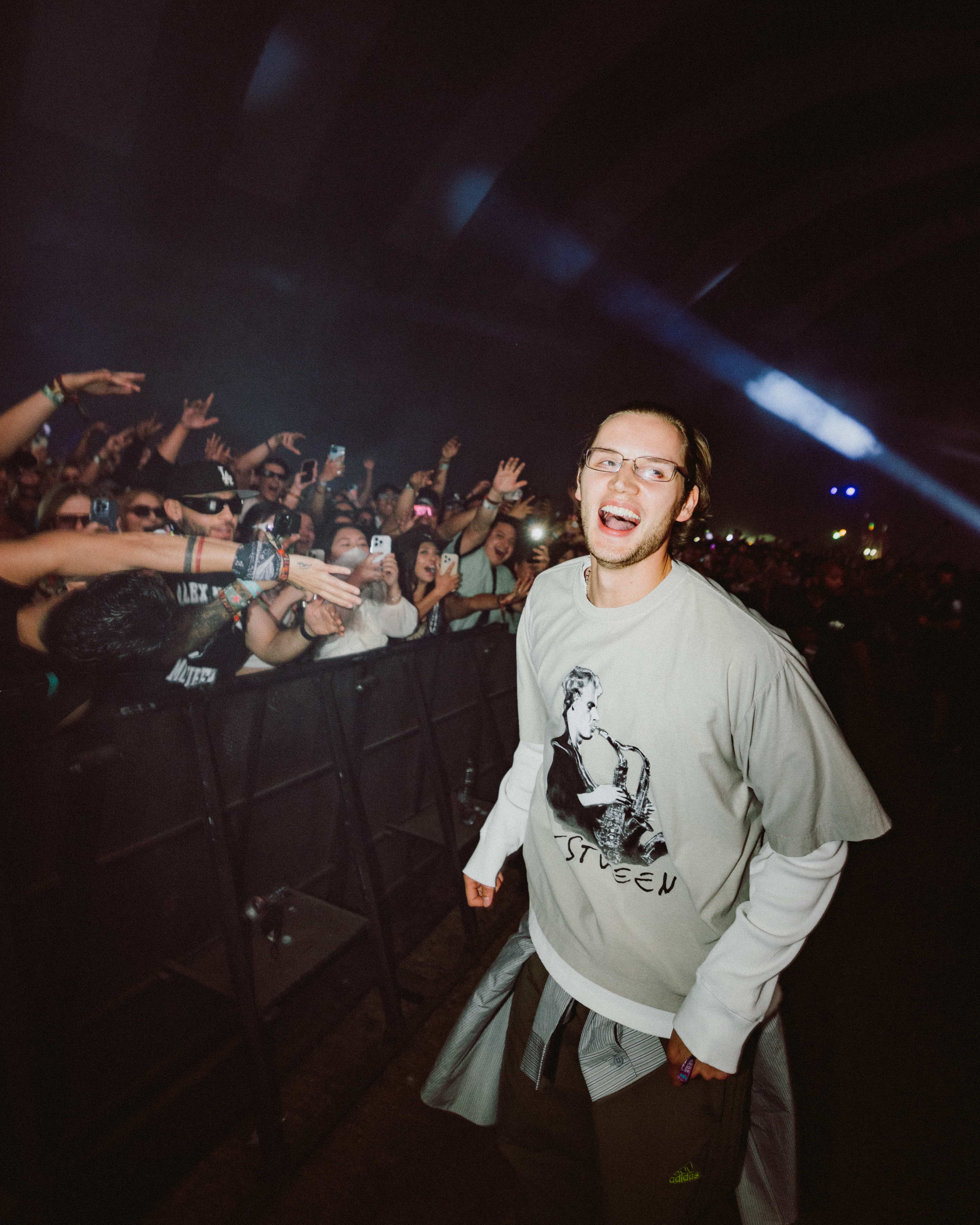 MAU P interacting with fans at Coachella 2025, walking alongside the crowd with hands reaching out, captured by A World Away creative director Brandon Densley
