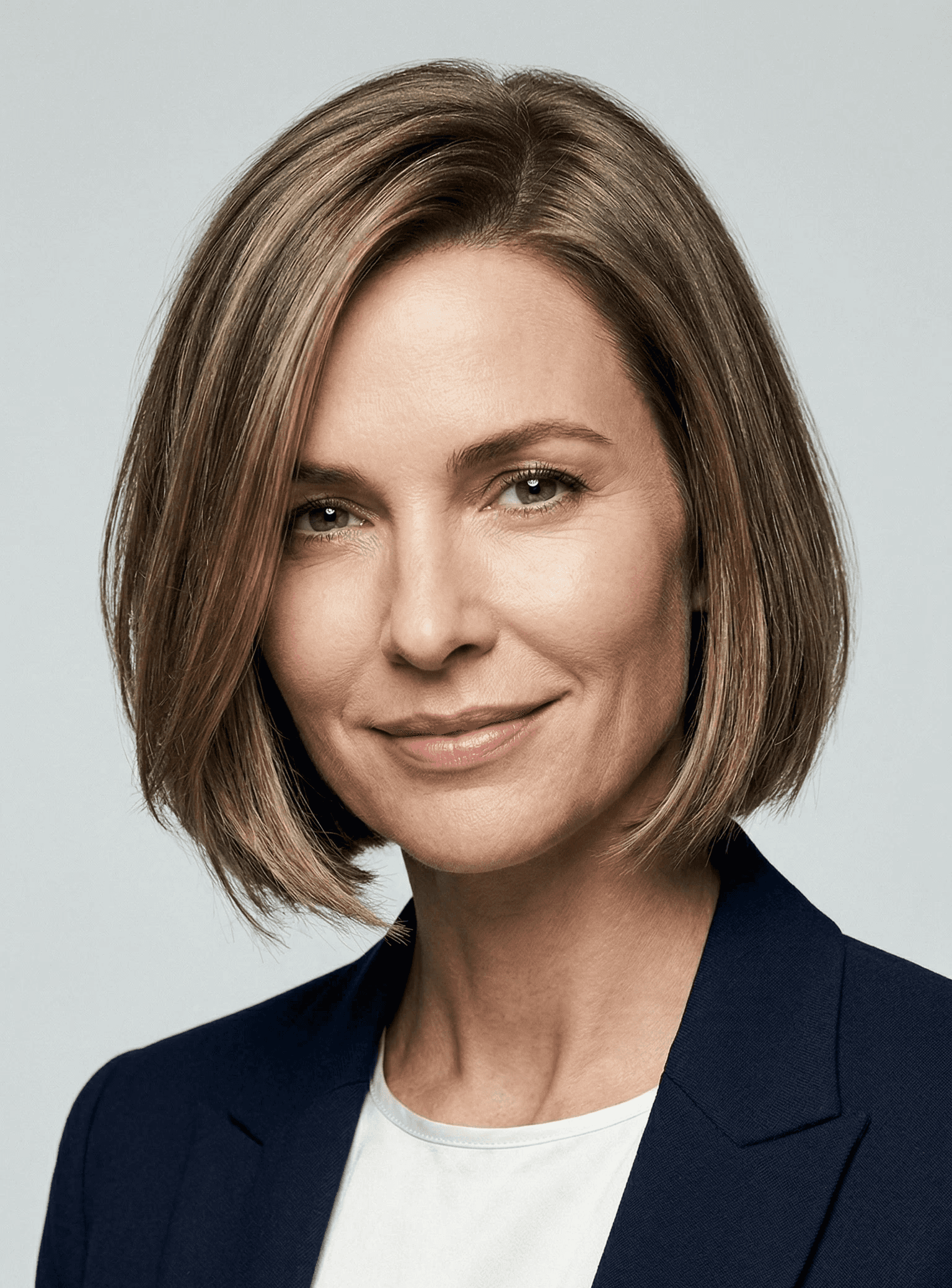 Smiling professional woman with short brown hair, wearing a navy blazer and white top, suitable for Reeltor Sydney real estate agent profile.