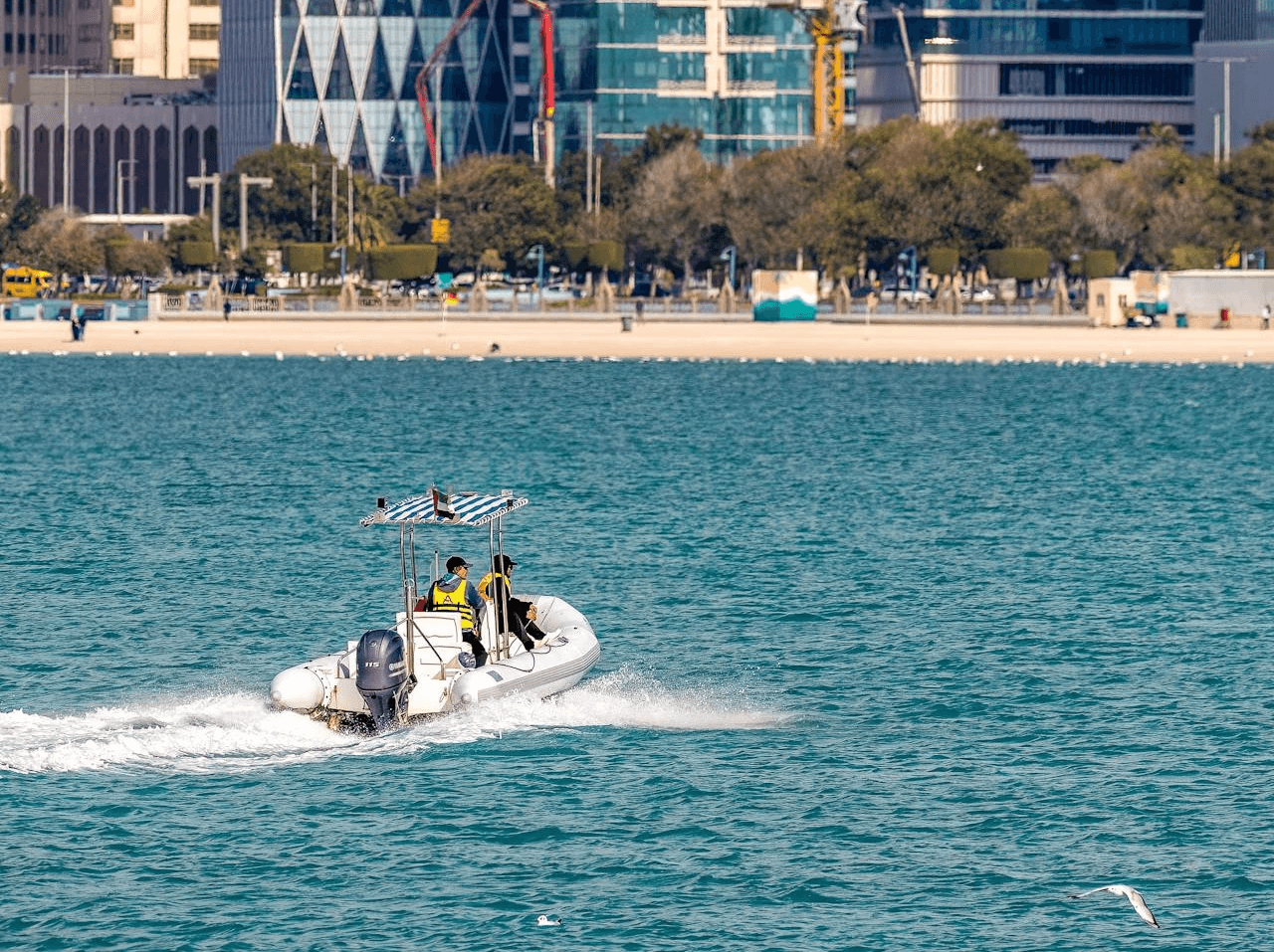 A speedboat cruises through the water on a speed boat, with the Dubai skyline as background.