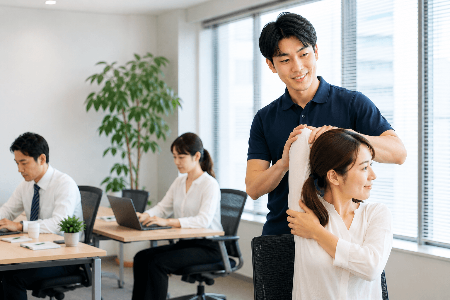 日本のオフィスで従業員がトレーナーのサポートを受けながらストレッチする様子
