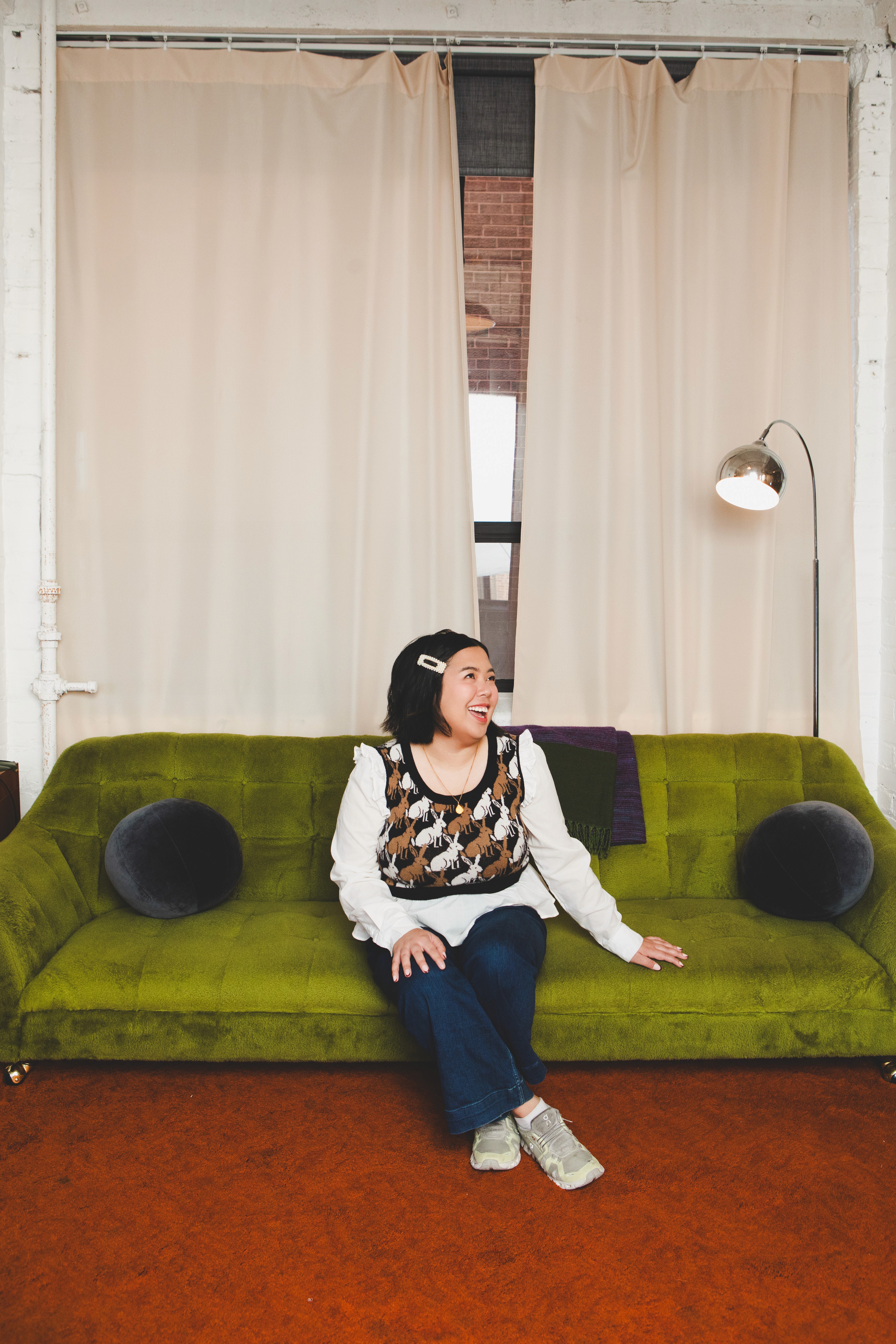 designer sitting on green couch