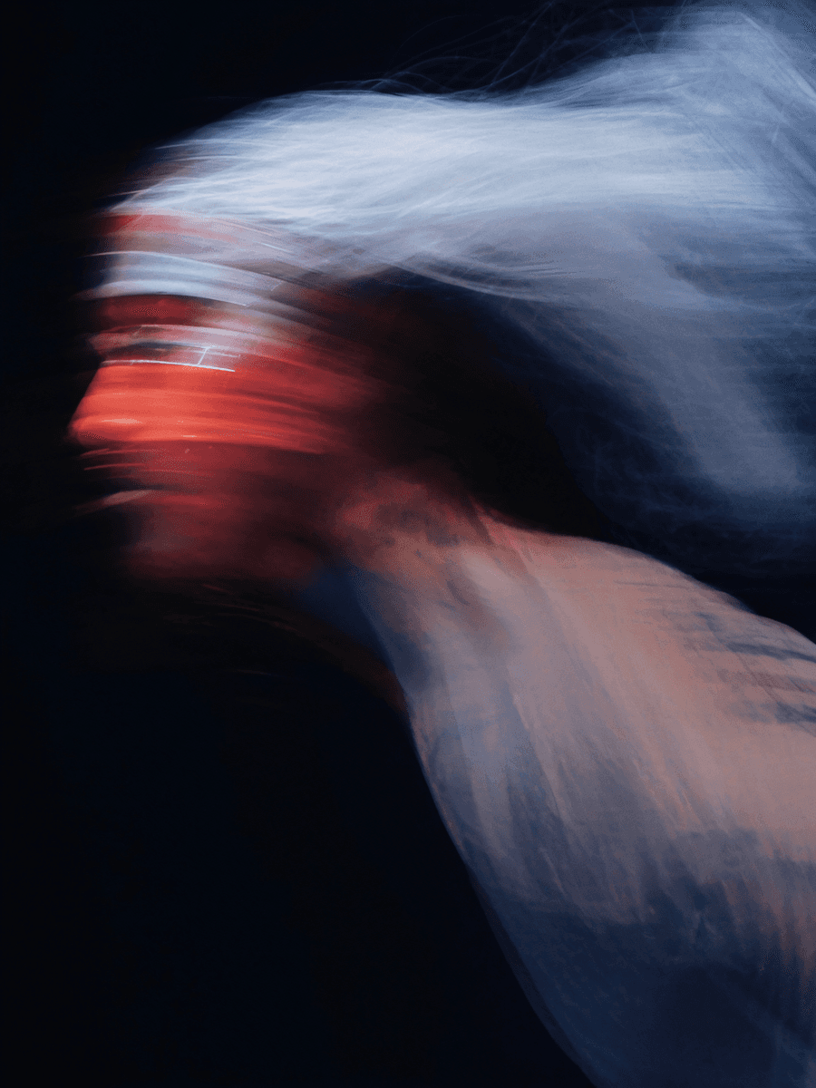 Blurred portrait of electronic artist performing under low light.