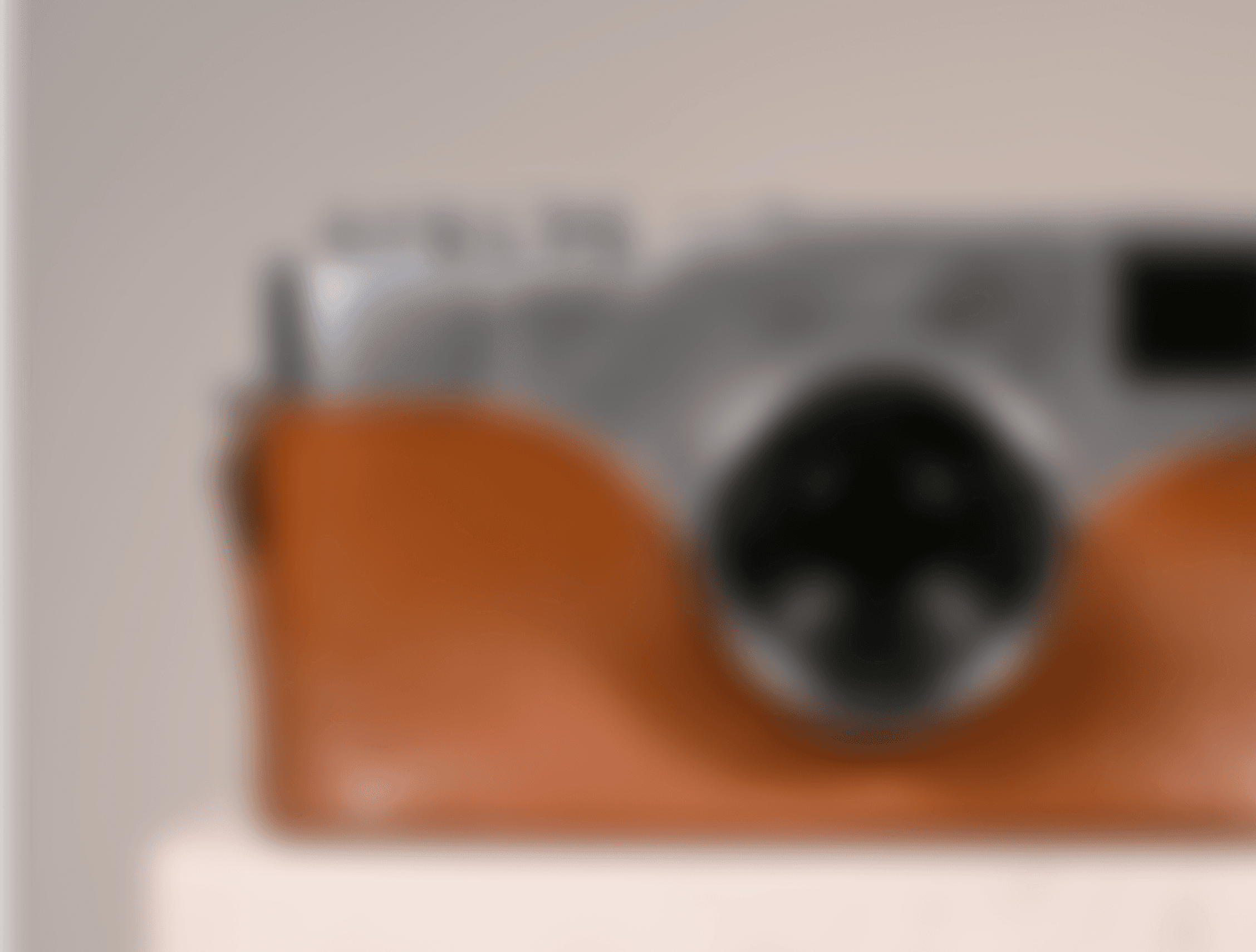 A vintage camera with a leather body, round lens, and visible signs of wear.