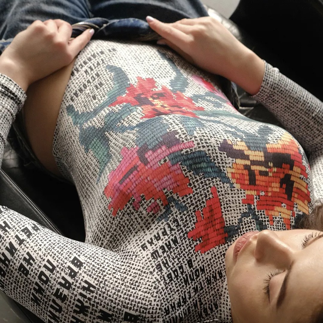Modern home office setup with a monitor, ergonomic chair, keyboard, and indoor plants near a window with blinds.