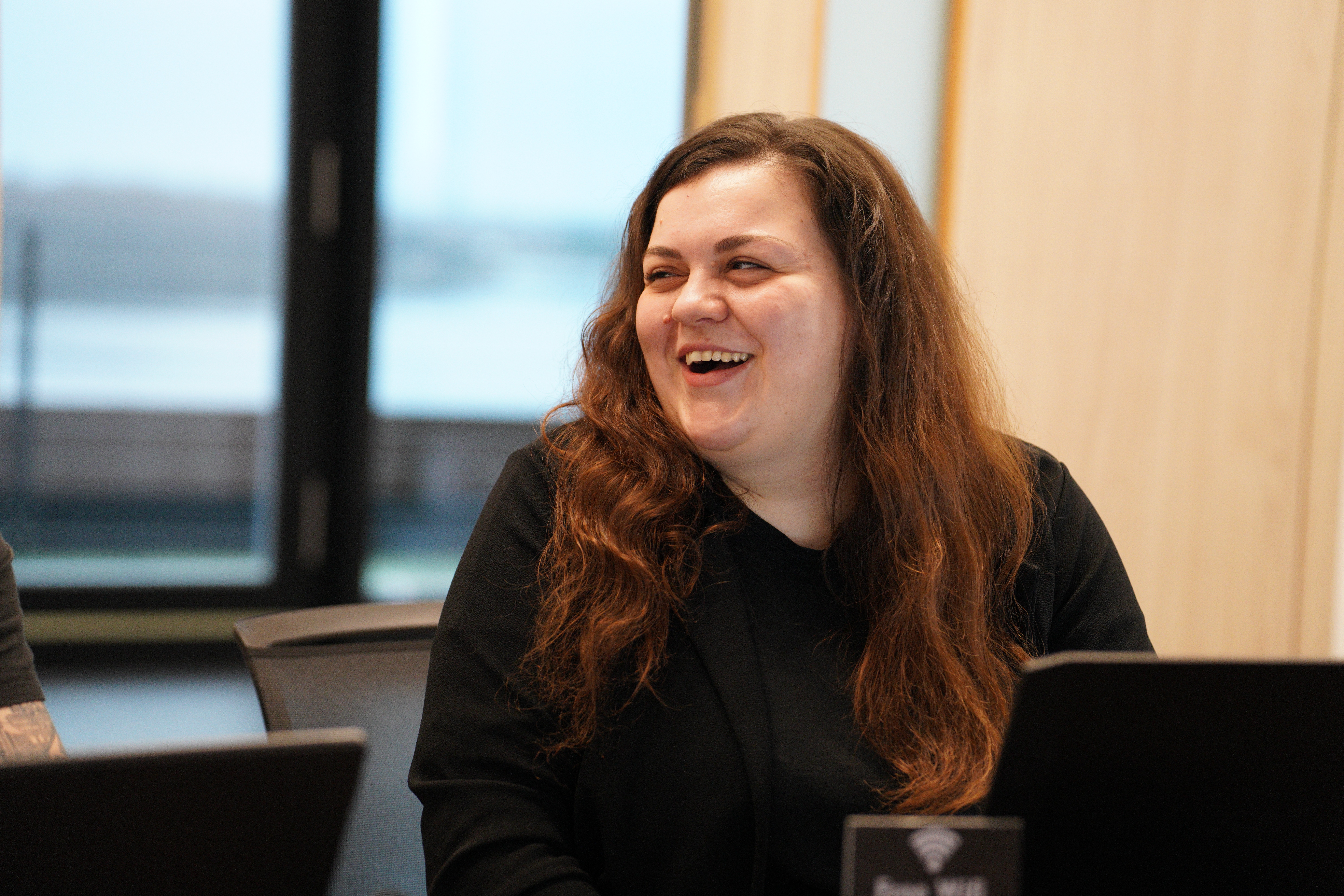  Collaborative work session overhead view of six people collaborating at a rustic wooden table with coffee, papers, and a laptop