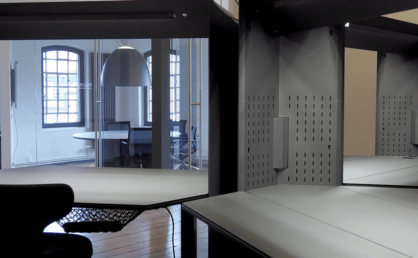 Offene Bürofläche mit modularen schwarzen SCOPE Elementen und flexiblem Raum-in-Raum Setup.