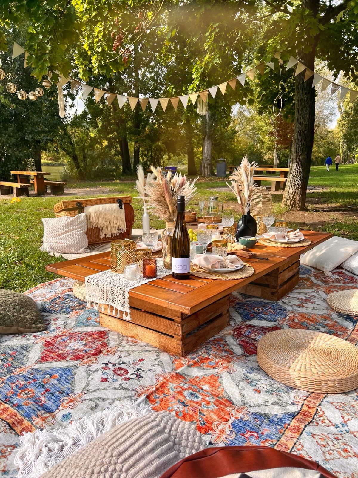Buntes JGA-Picknick am Mainufer in Wuerzburg für eine Mädelstruppe mit Sekt und bunten Kissen