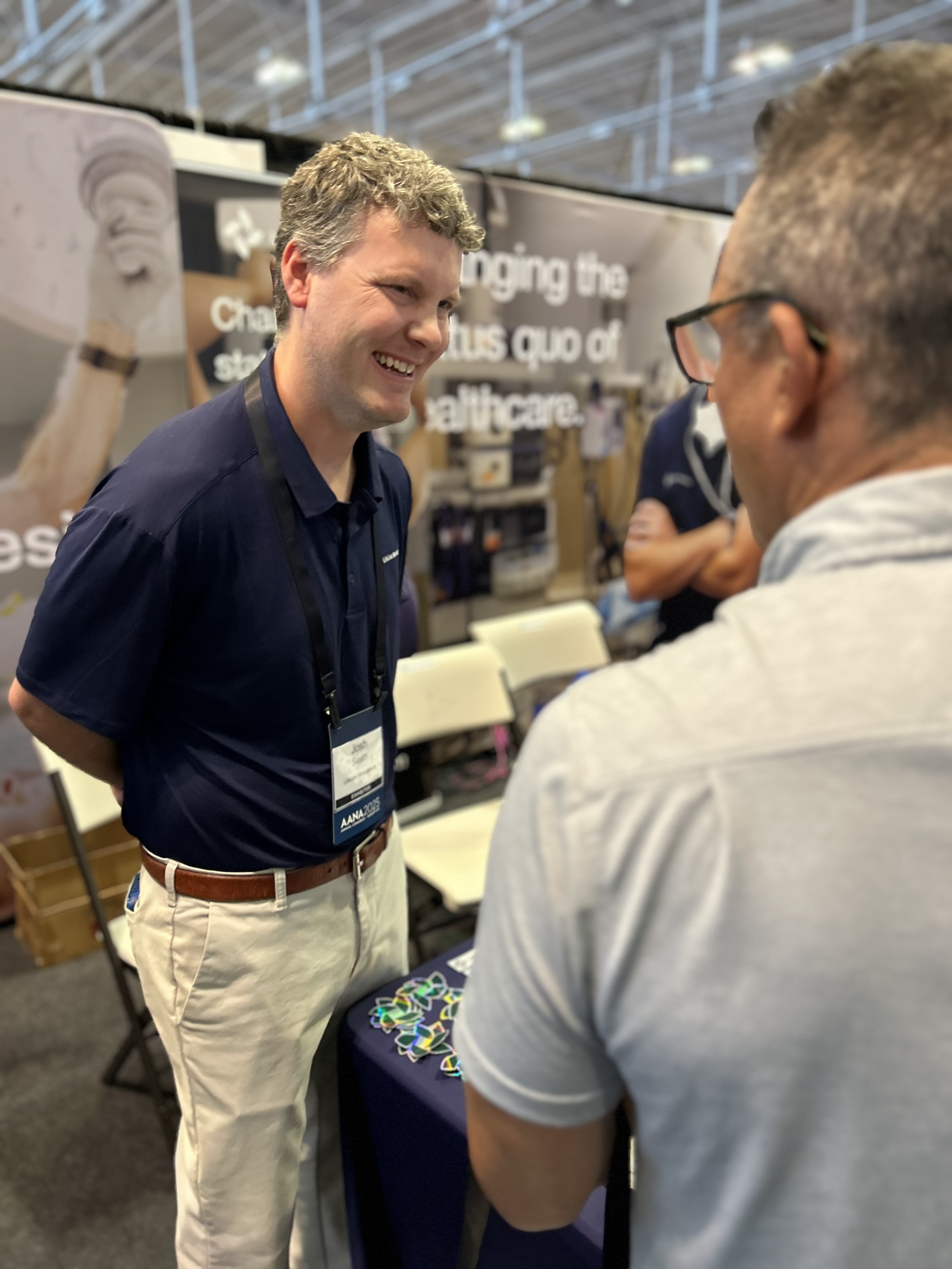 A LifeLinc representative smiles and engages with a candidate or colleague at a professional conference, representing anesthesia recruitment and staffing services