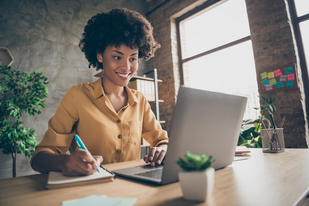 Woman working on a laptop in a cozy home office setting