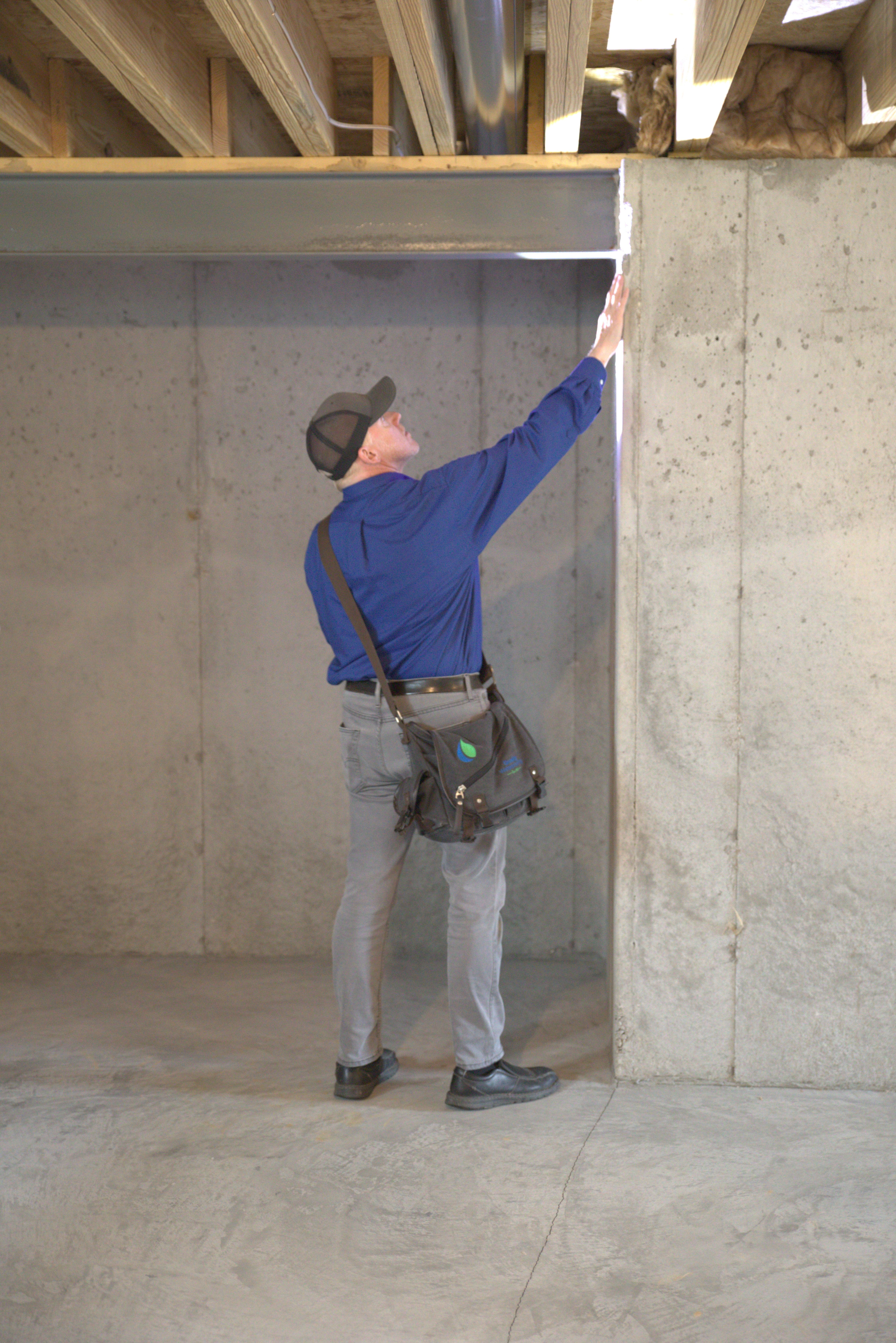 a technician inspects a basement foundation wall