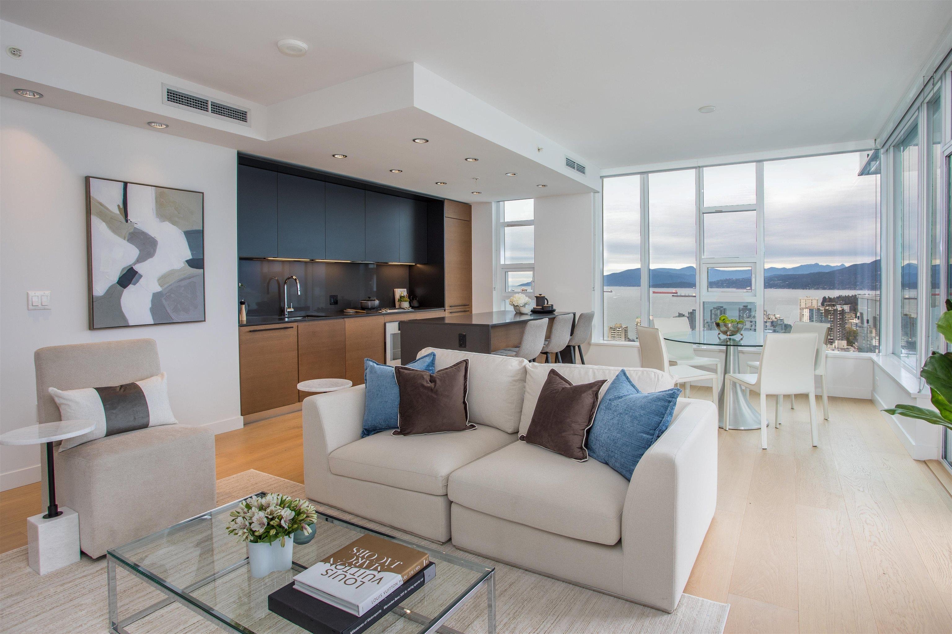 Modern living room with light-colored furniture, large windows, and a contemporary design, offering a spacious feel.