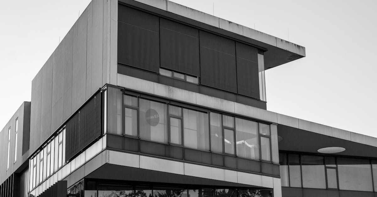 Sleek modern building showcasing geometric shapes and glass facade in black and white.