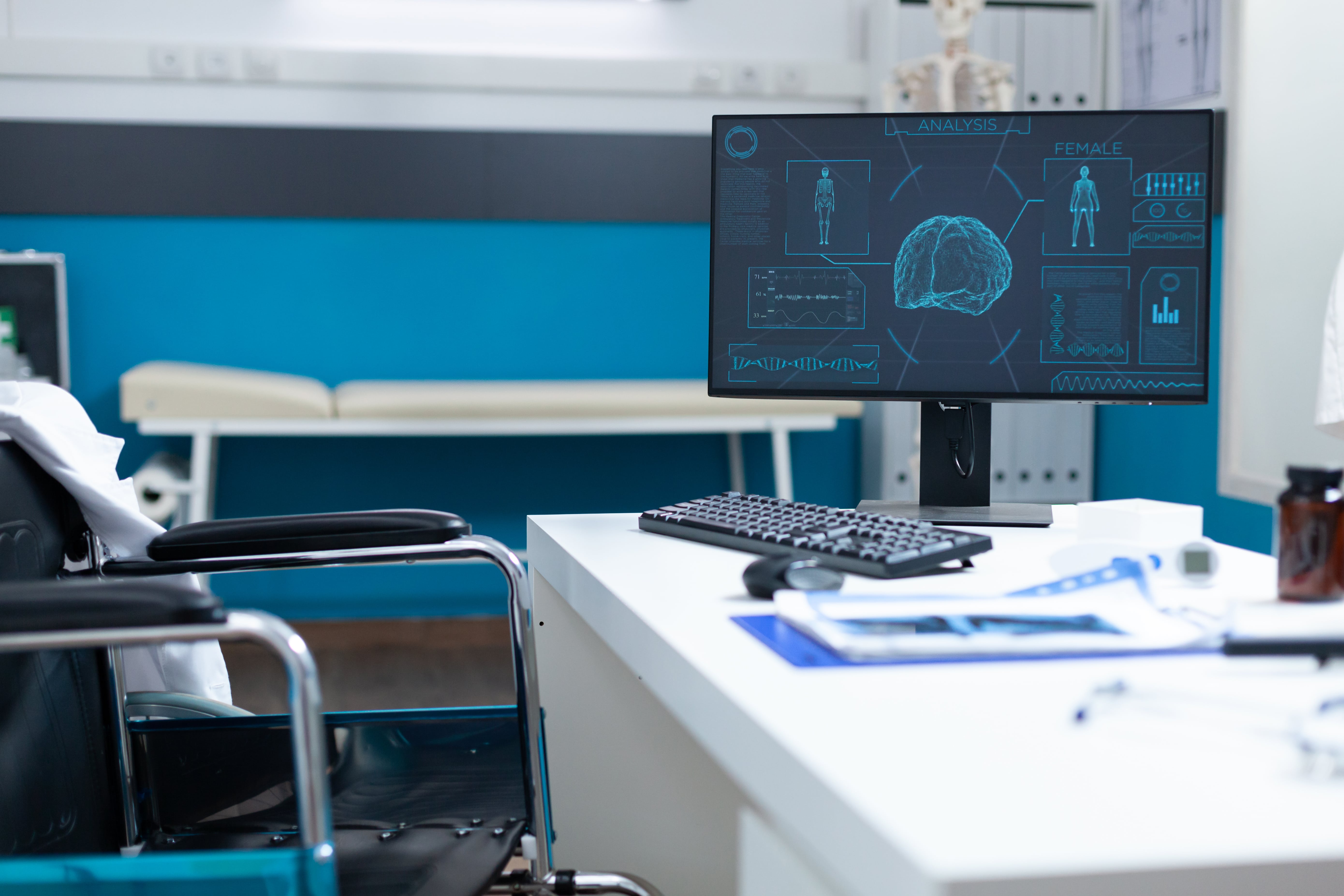 An empty doctor's office with a wheelchair and a computer on the desk showing a futuristic brain analysis and patient's vital signs for advanced diagnosis.