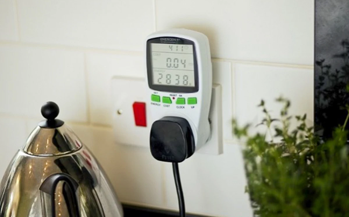 A photo of a uk plug socket with an energy monitor plugged in and a kettle plugged into that.
