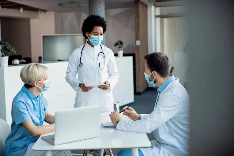 american doctor talking her colleagues while working medical clinic