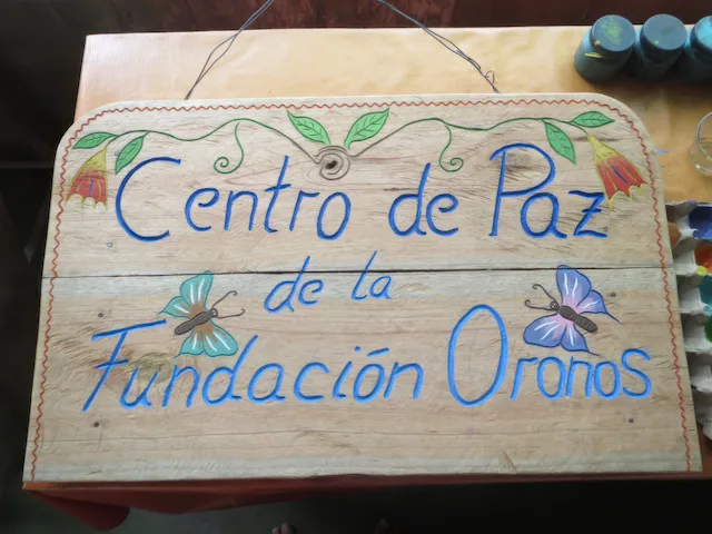 Handbemaltes Holzschild 'Centro de Paz de la Fundación Oronos' im Friedenszentrum Peru.