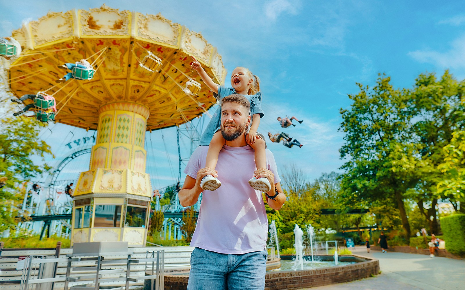 Father and daughter enjoying carousel ride at Bobbejaanland theme park.