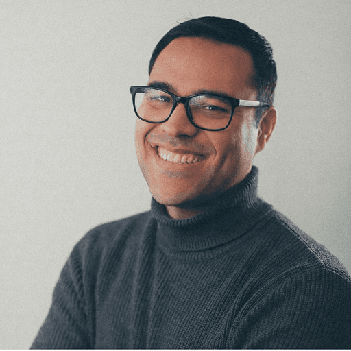smiling man standing near green tree