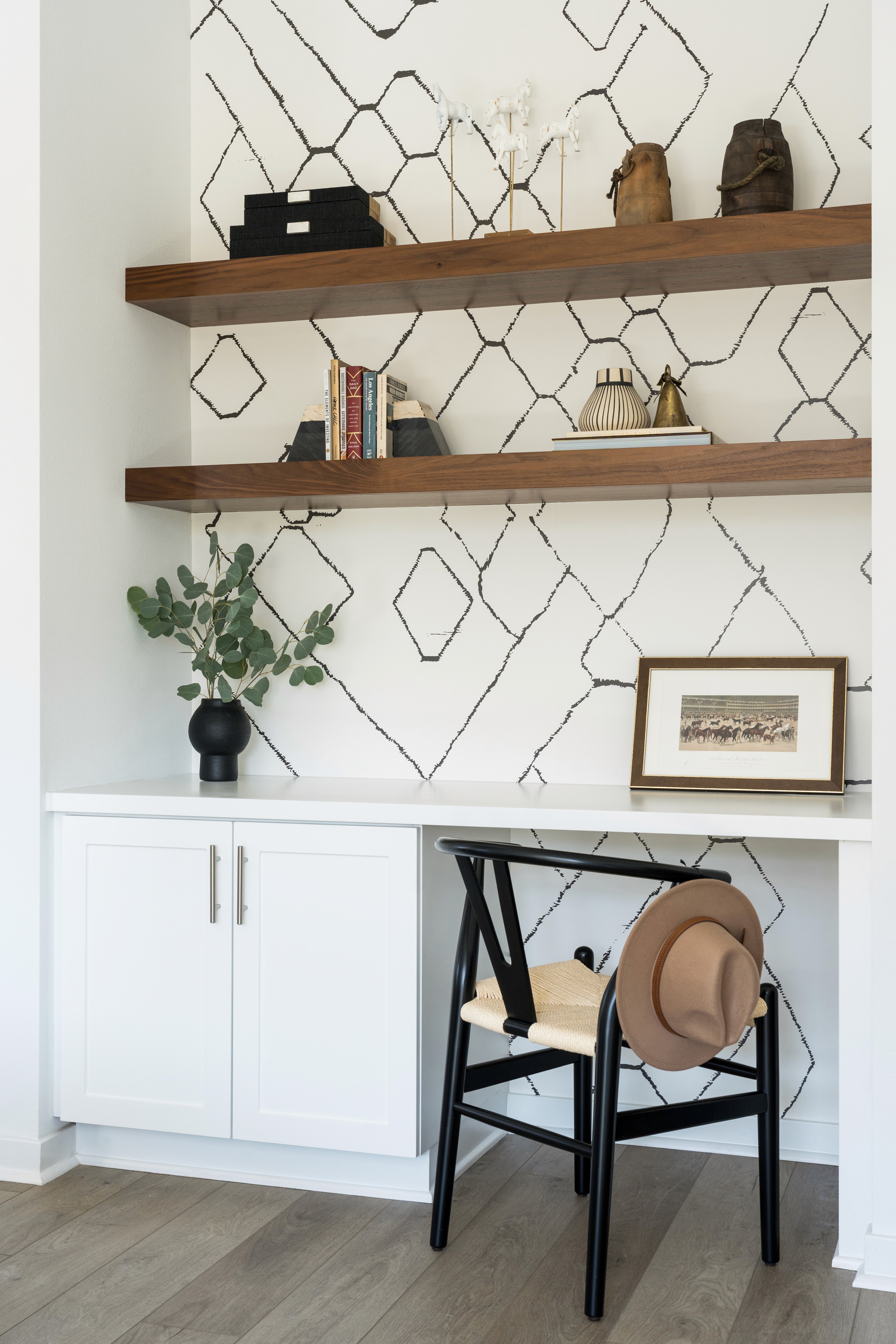 Built-in desk area with wood shelving, white cabinetry, black wood and off-white rope office chair, black vase, and western decorative pieces by Jubilee Interiors in Arcadia, California