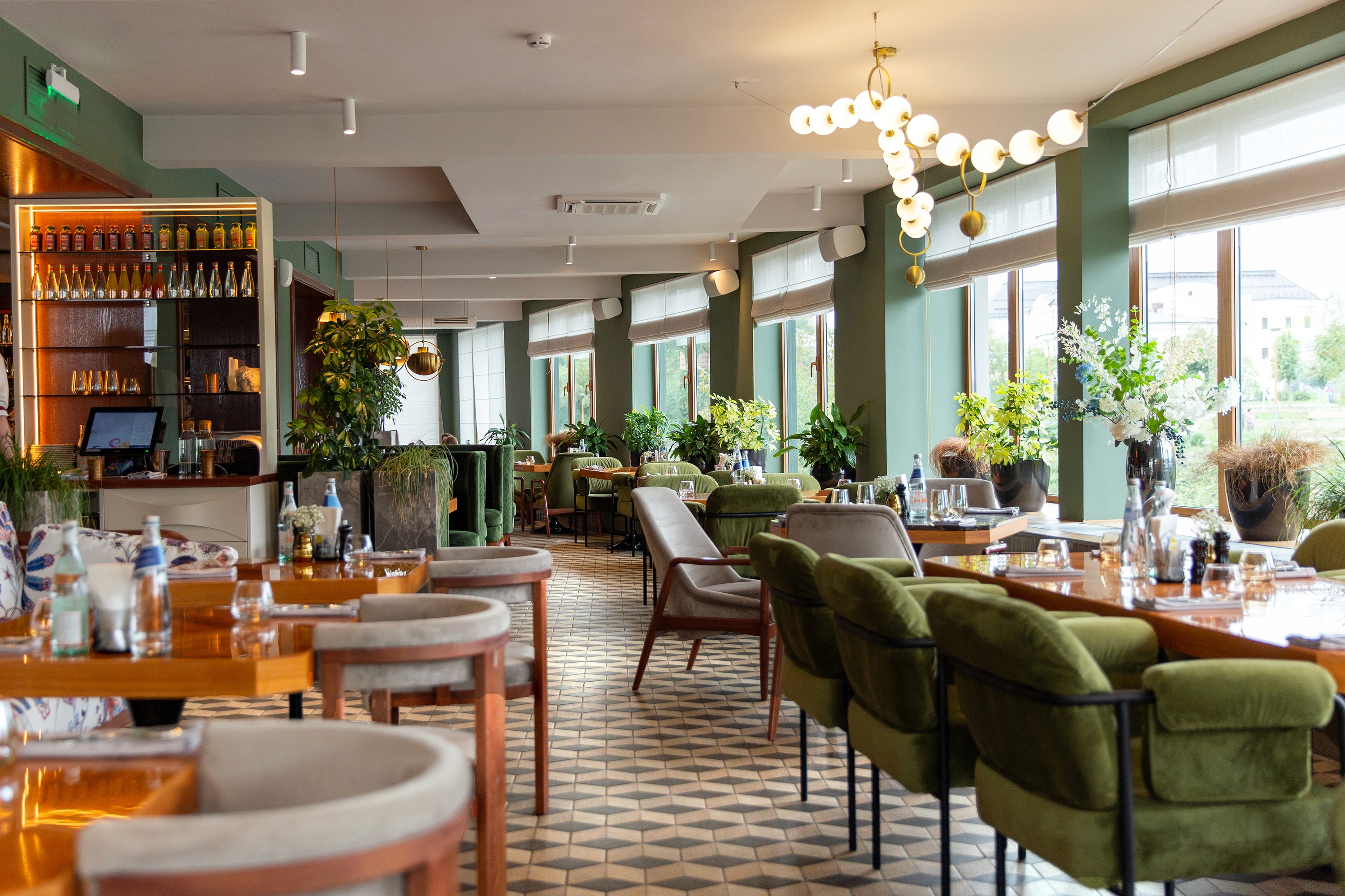 Green restaurant interior with green velvet chairs