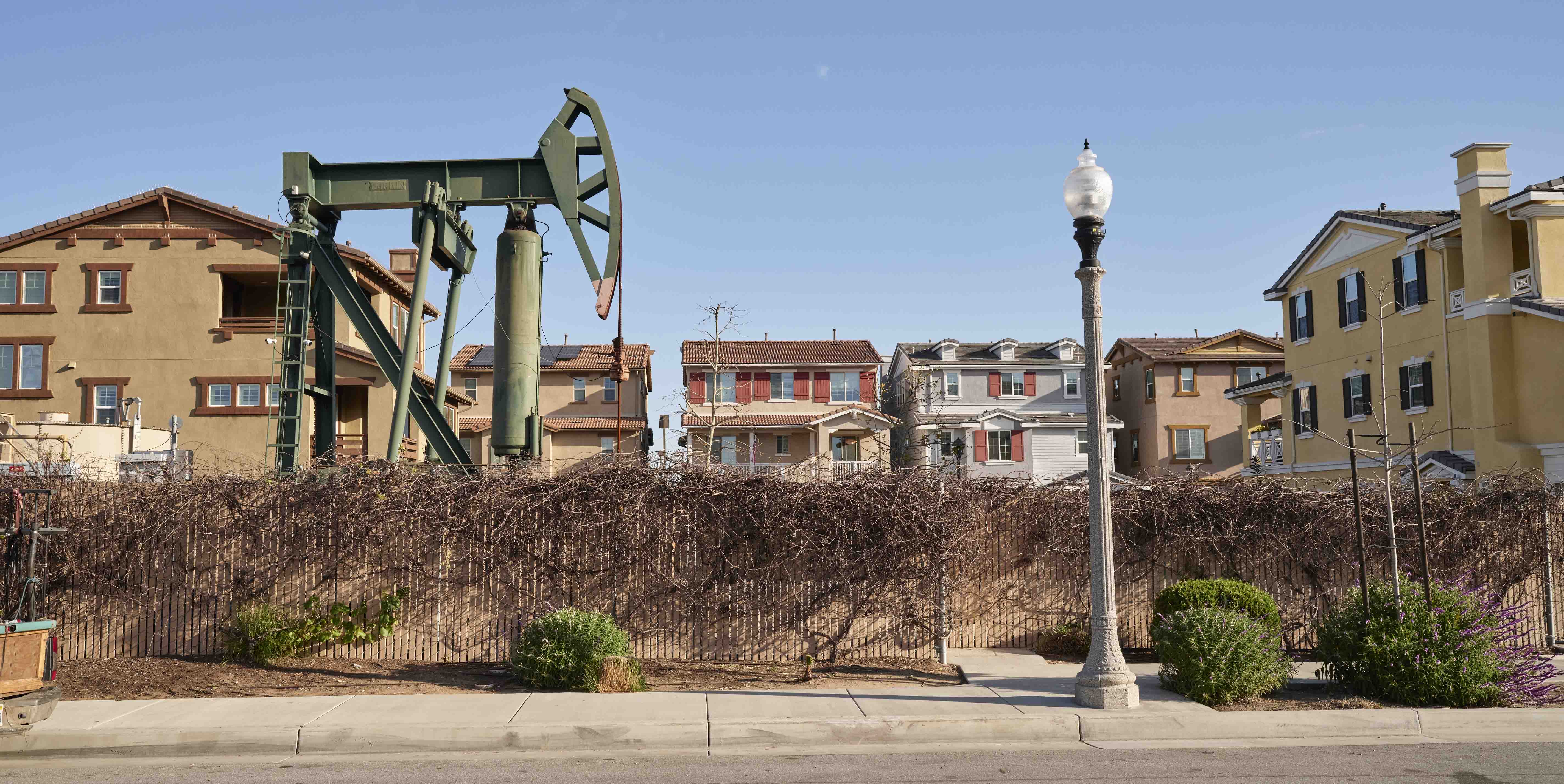 An oil rig next to houses in California.