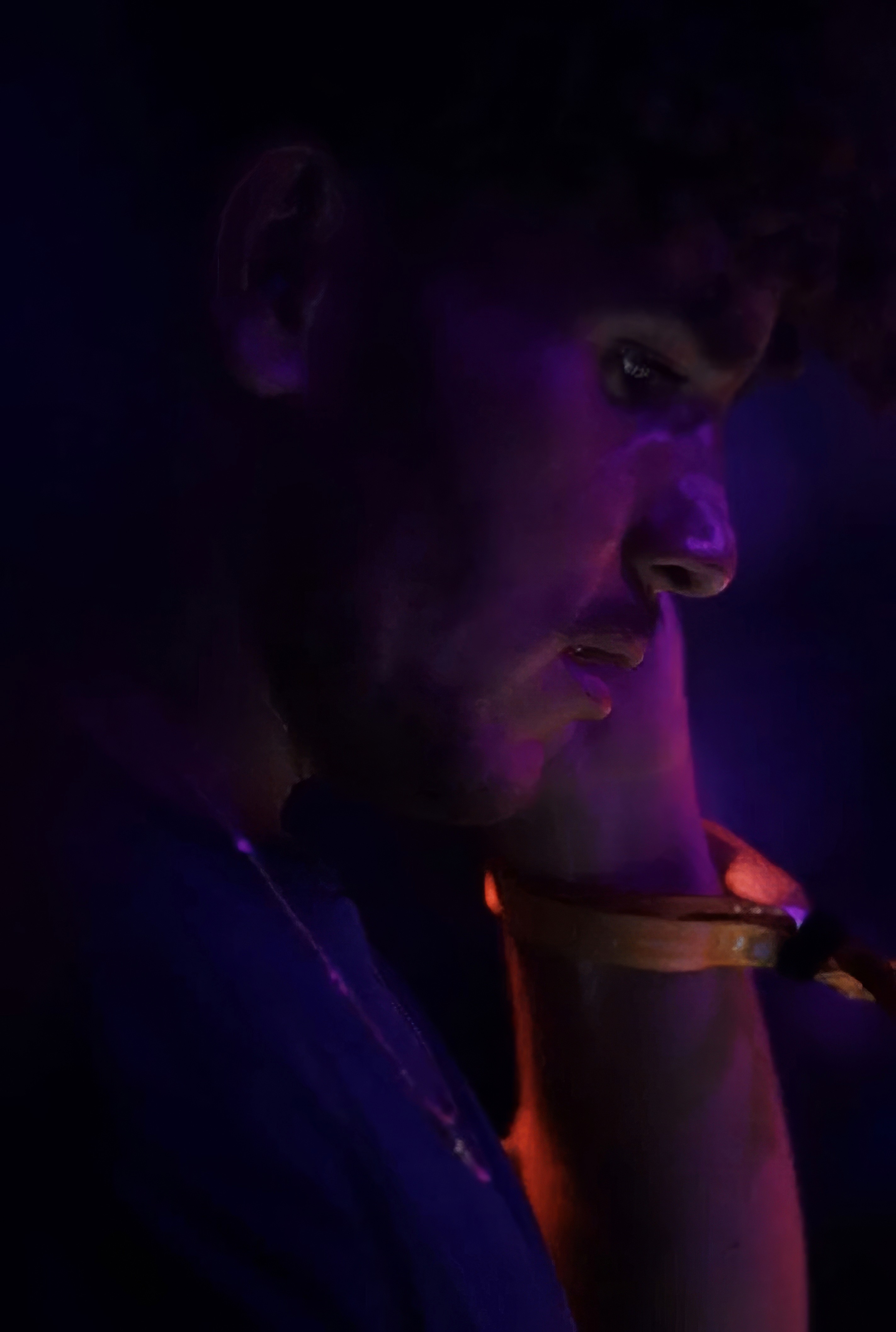 Bride sitting on ground against wall, groom standing nearby