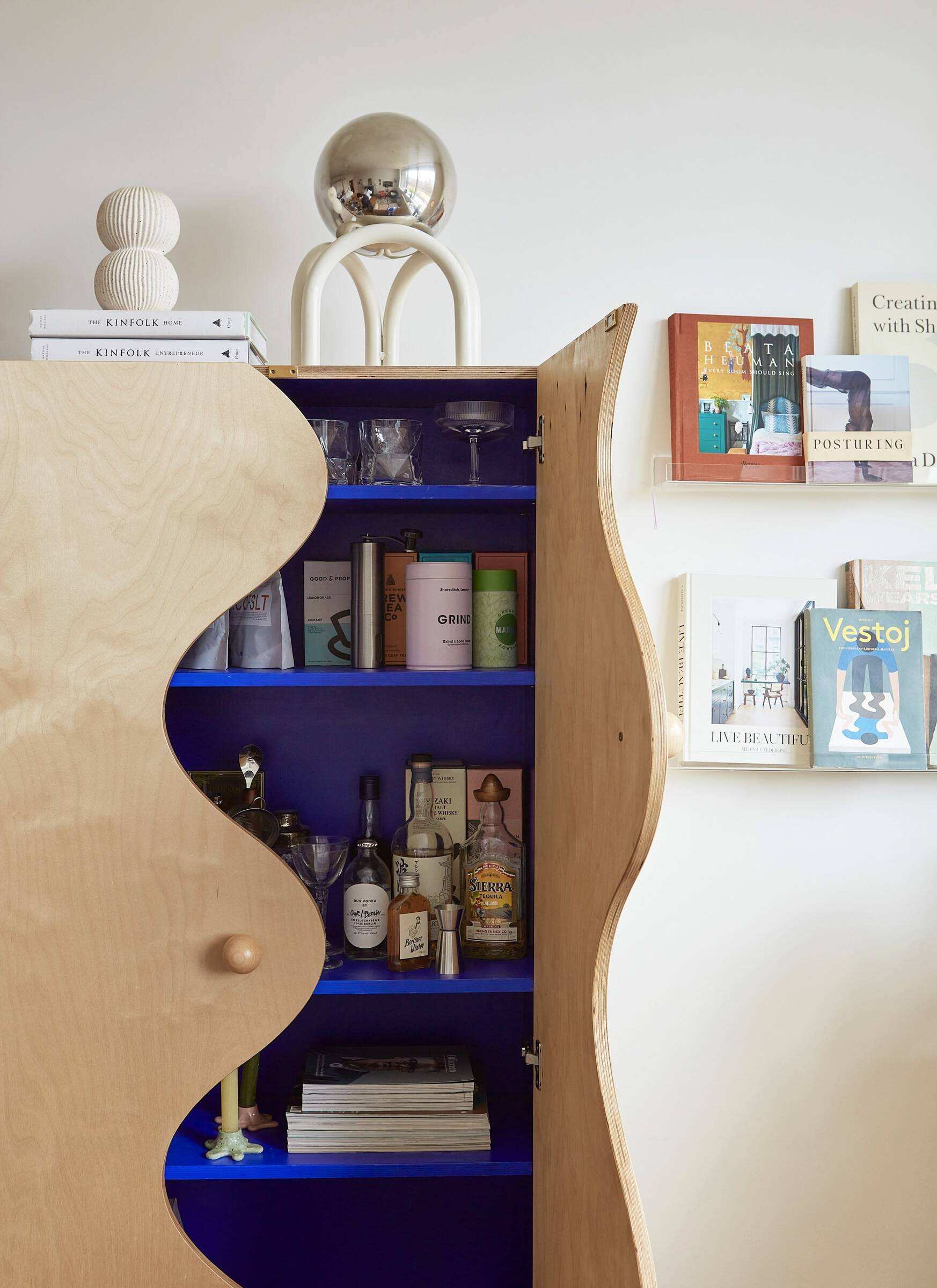 Characterful bespoke cabinet with wiggly door, with cobalt blue internals, in London new build interior design.