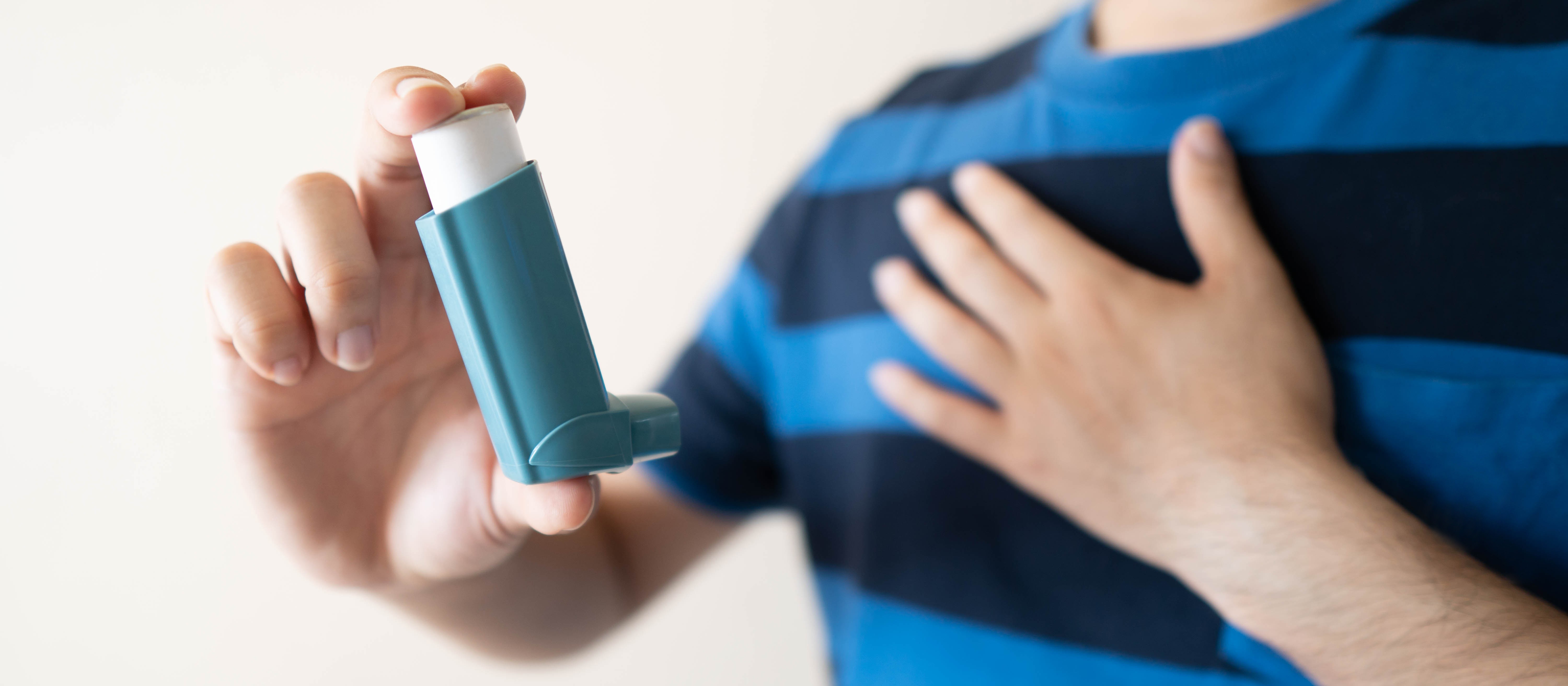 Person using an asthma inhaler.