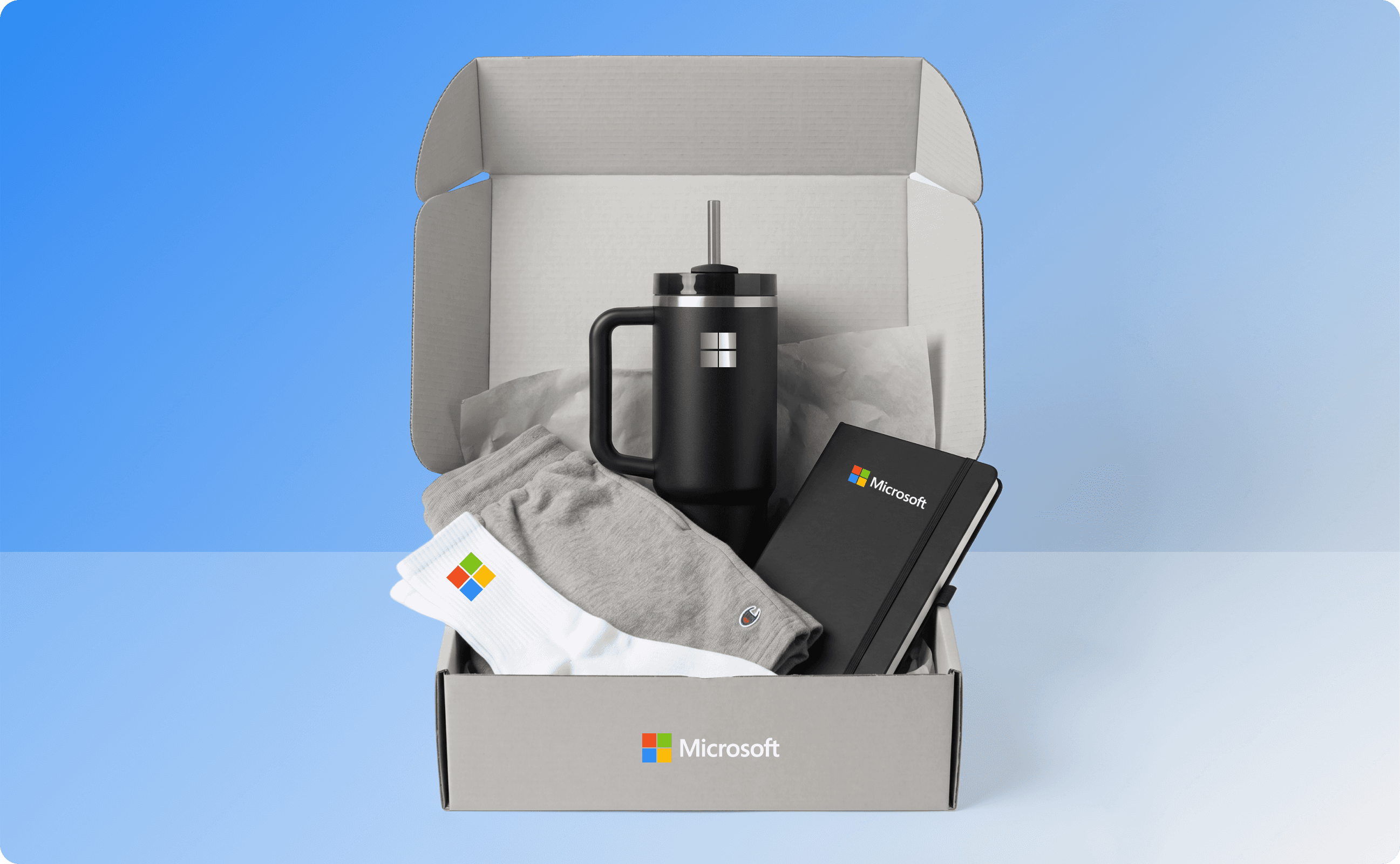 Microsoft new hire swag kit that contains socks, tumbler, notebook, shorts, and apparel.