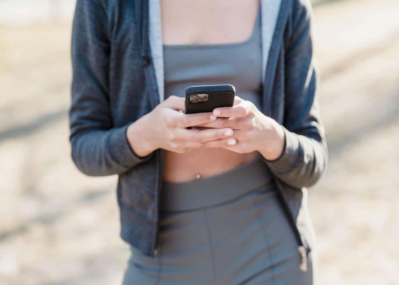 Woman in workout clothes looking at smartphone