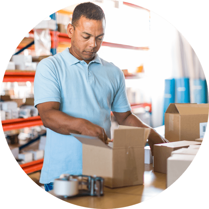 A person packing a box preparing it for shipping