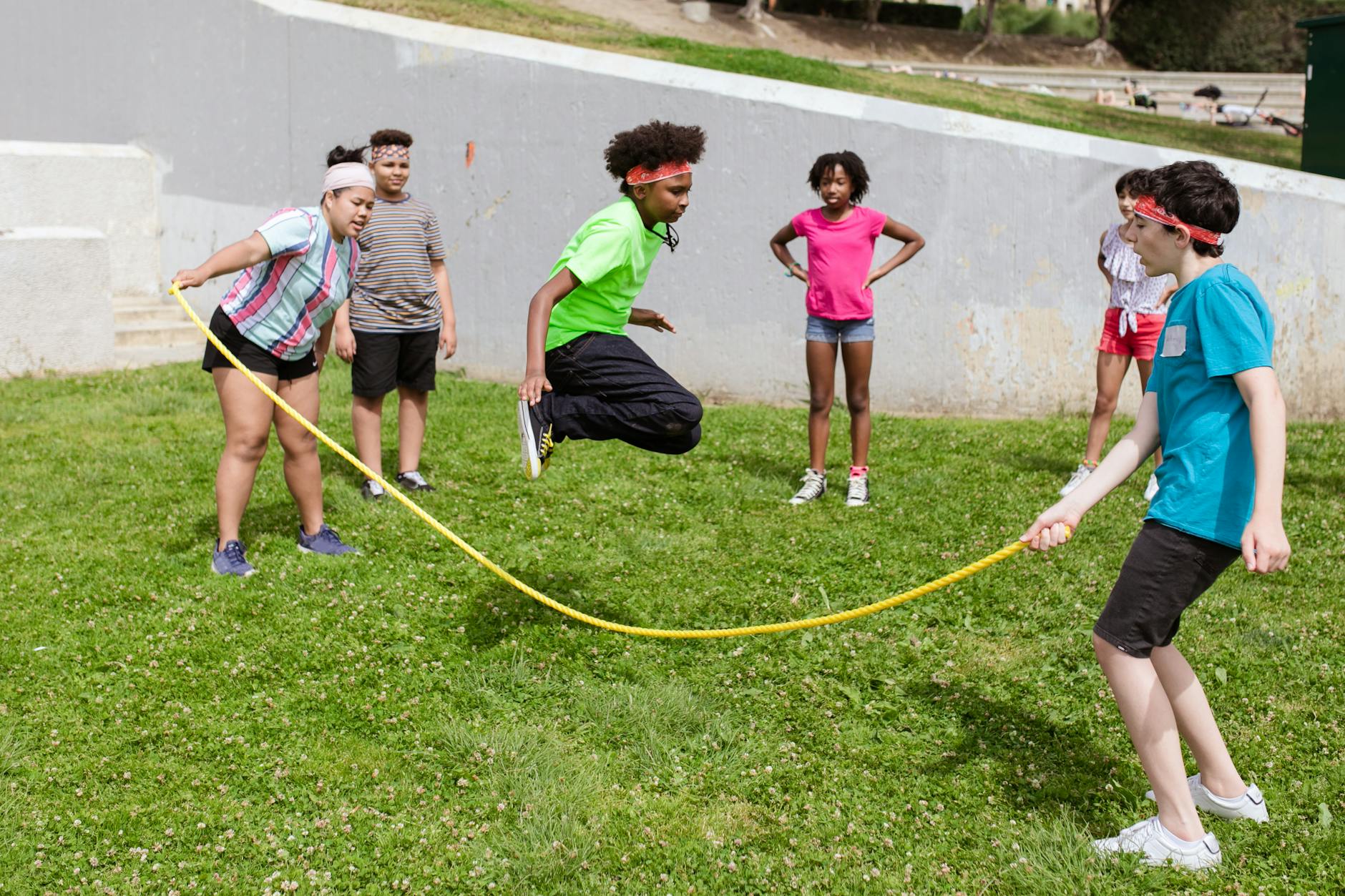Young elementary children hopping through a colorful sequence of rubber floor spots to develop pe lesson plans.