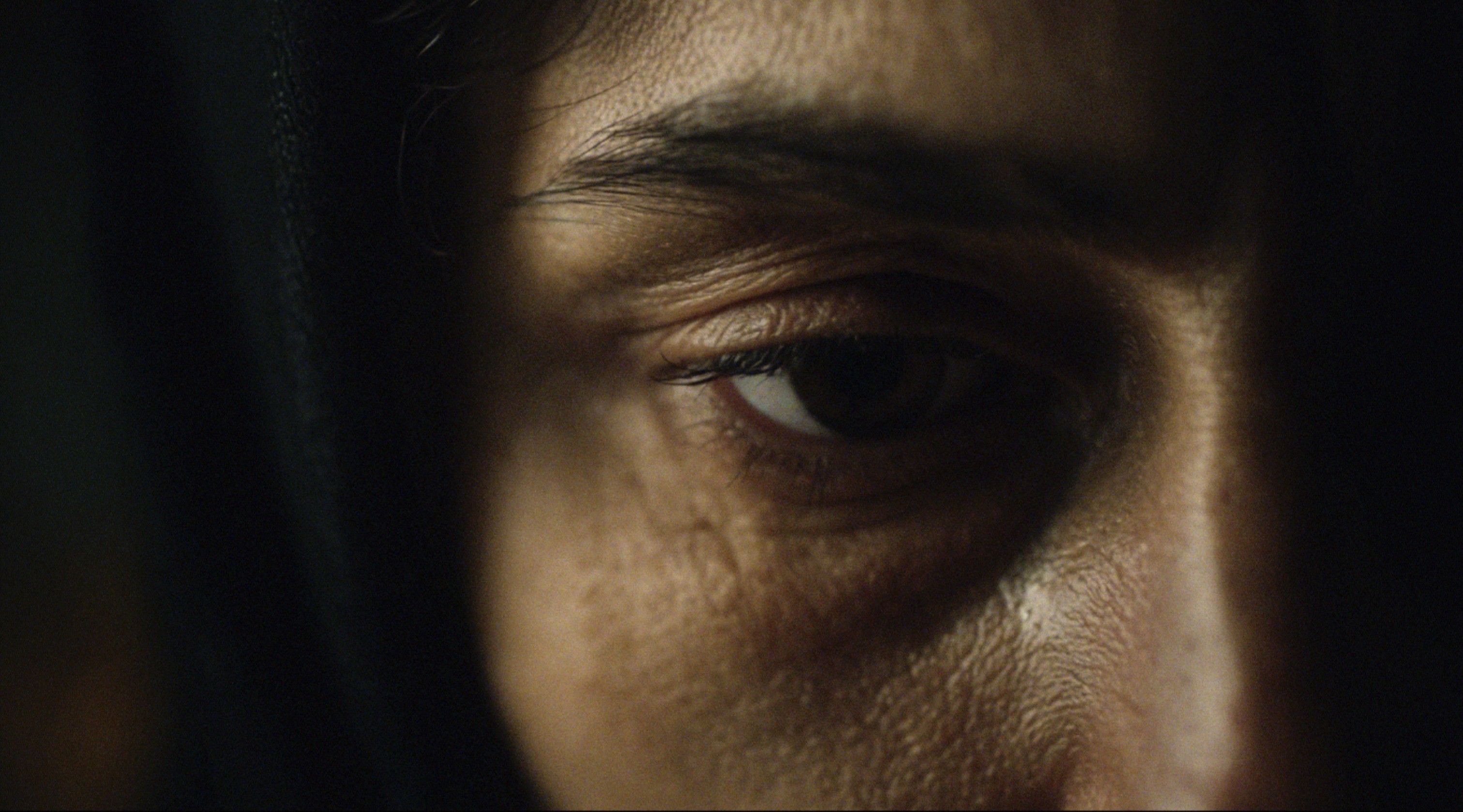 AI-generated cinematic close-up of a person’s eye, showing detailed skin texture and dramatic lighting for a realistic emotional film-style shot.