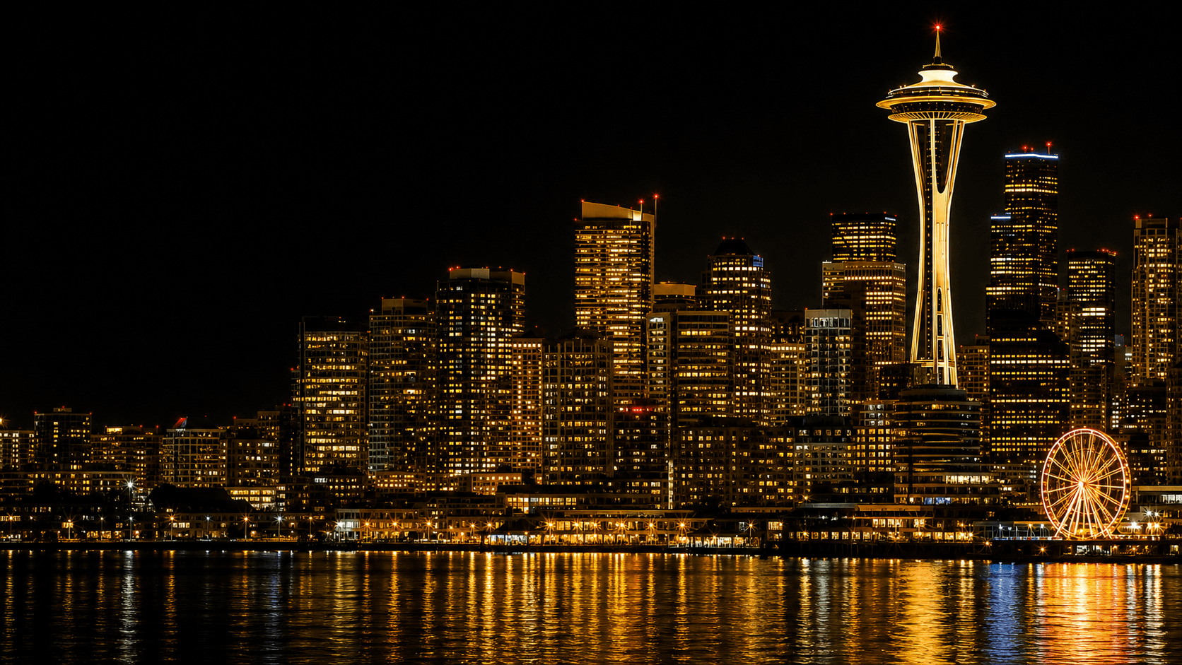 Vibrant Seattle skyline at night with the Space Needle, waterfront lights, and gold reflections