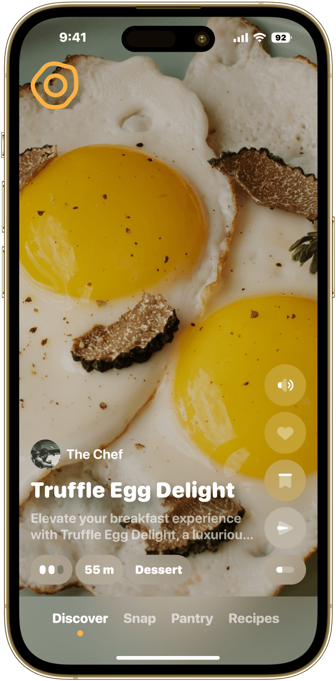 A smartphone screen displaying a recipe app featuring "Truffle Egg Delight" by "The Chef." The background shows a close-up image of sunny-side-up eggs with truffle slices. The app interface includes a brief description of the dish and indicates a preparation time of 55 minutes, categorized under "Dessert." Navigation options at the bottom include "Discover," "Snap," "Pantry," and "Recipes." The top of the phone screen shows the time as 9:41 and the battery level at 92%.