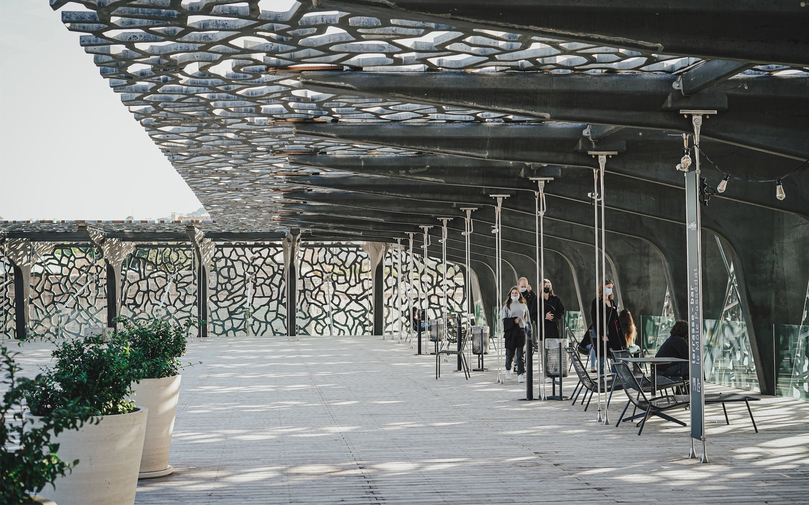 Mucem Marseille-terras met bezoekers die onder het ingewikkelde roosterdak lopen.