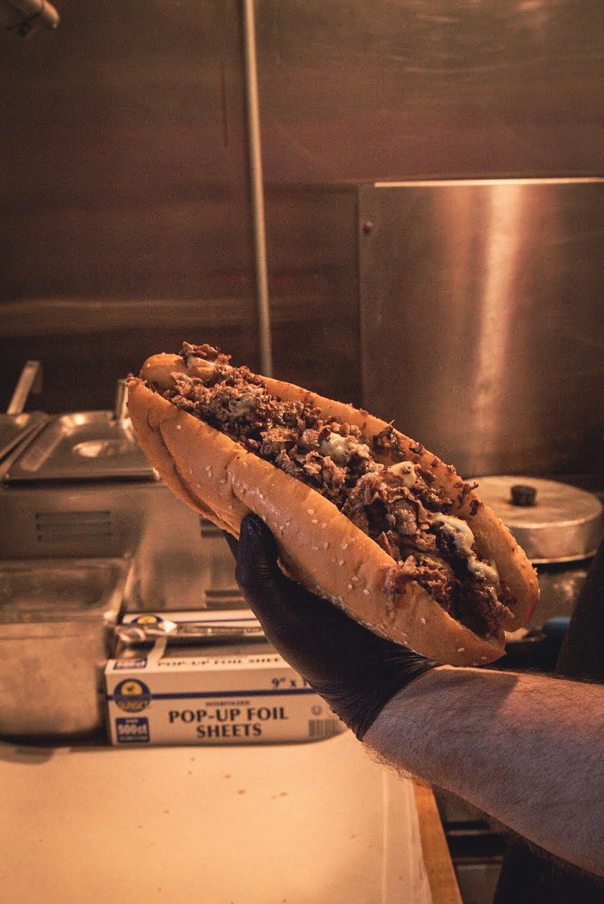 Freshly grilled steak and cheese sub being prepared at Big Jim’s Roast Beef in Pacific Beach, San Diego, highlighting their hearty sandwiches and authentic Massachusetts-style comfort food.