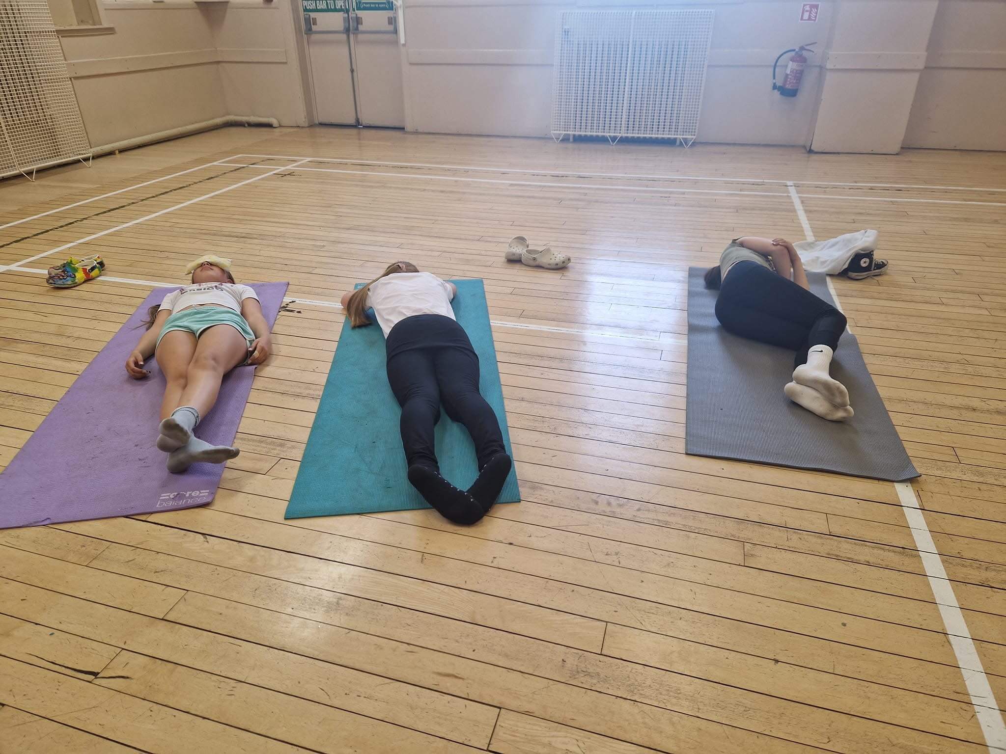 A group of young people lying on yoga mats in different positions