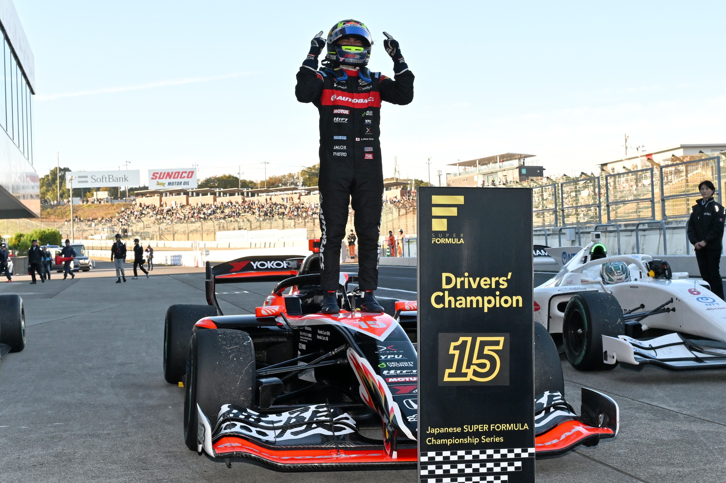 Ayumu Iwasa stands on top of his Super Formula car to celebrate the championship