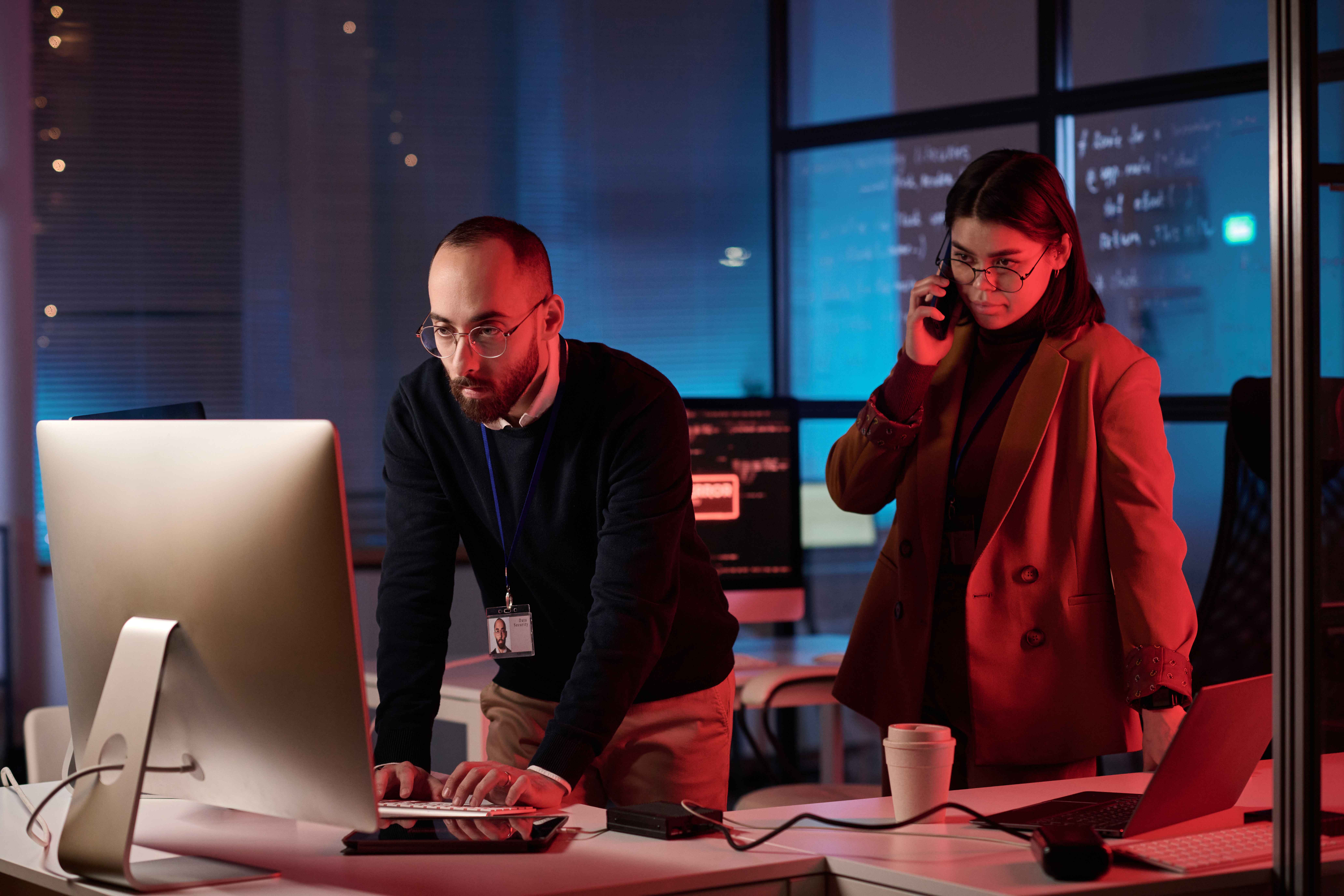 Mitarbeiter von detacon stehen vor einem Computer und arbeiten konzentriert an der IT-Security eines Unternehmens