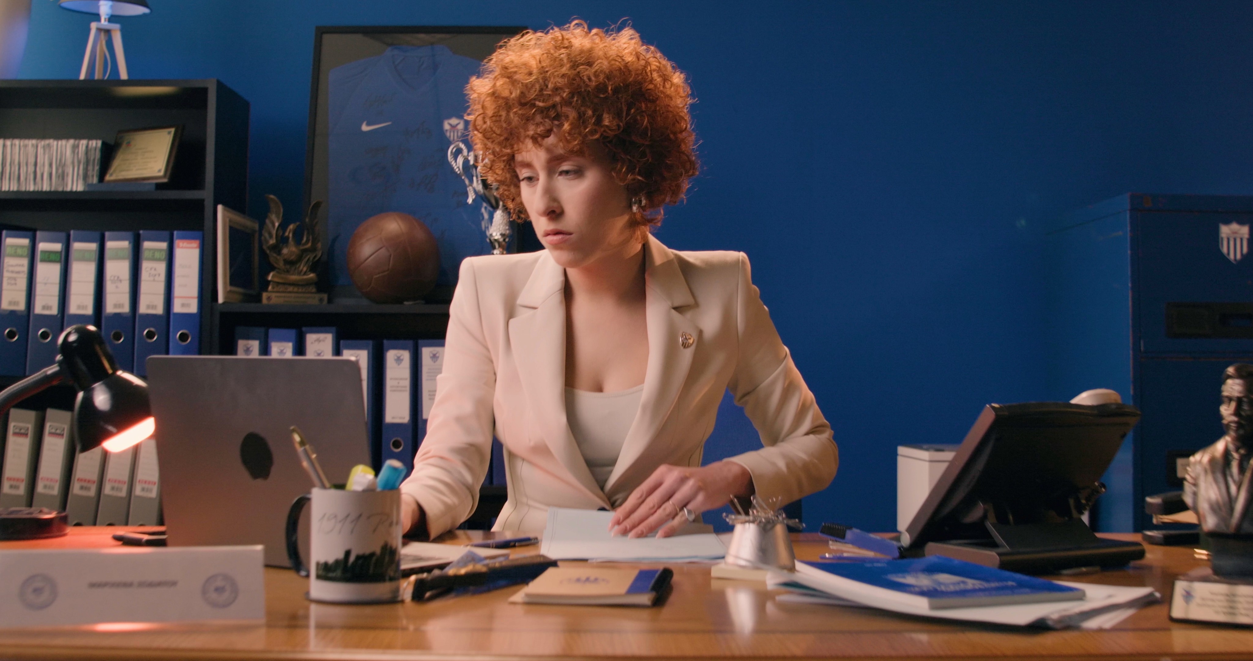 A busy secretary working at her office, focused on tasks at her desk.