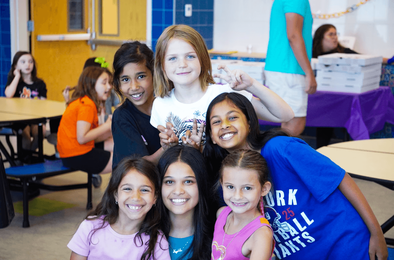 A group of students smiling in a classroom