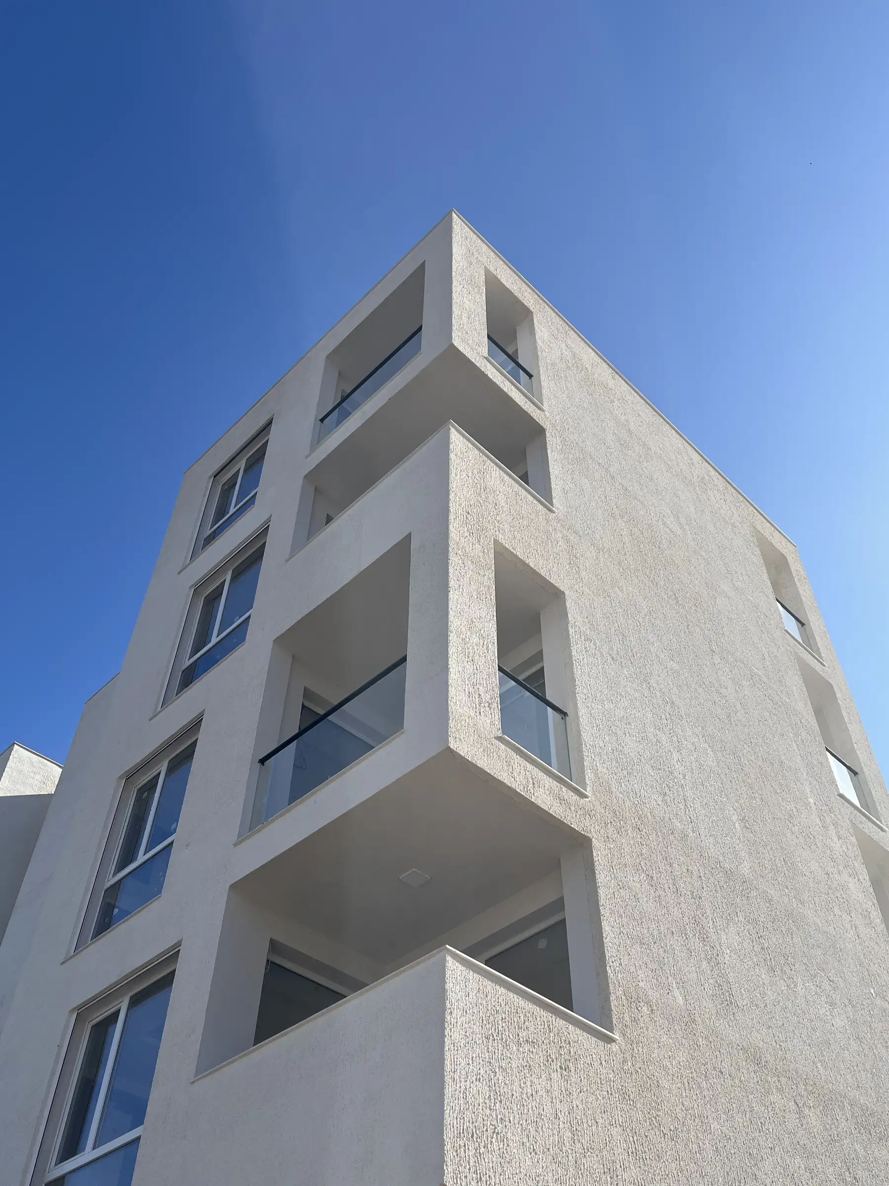 Projecting balcony volumes seen from below against the sky